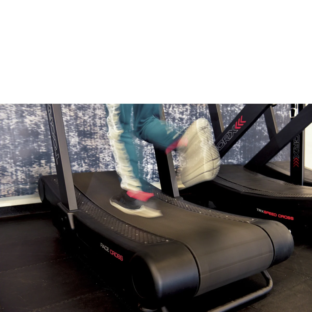 Personne courant sur un tapis roulant. Tapis roulant noir et rouge. Mouvement flou des pieds.