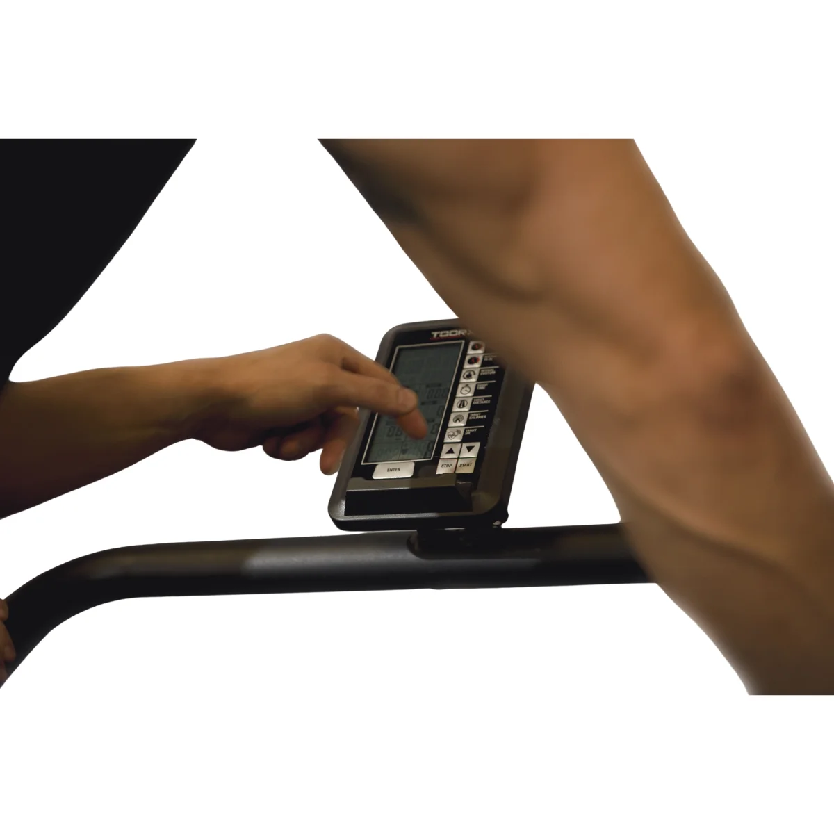 La main touche l'écran noir d'une console de tapis roulant. L'écran affiche des données. Le fond est blanc.