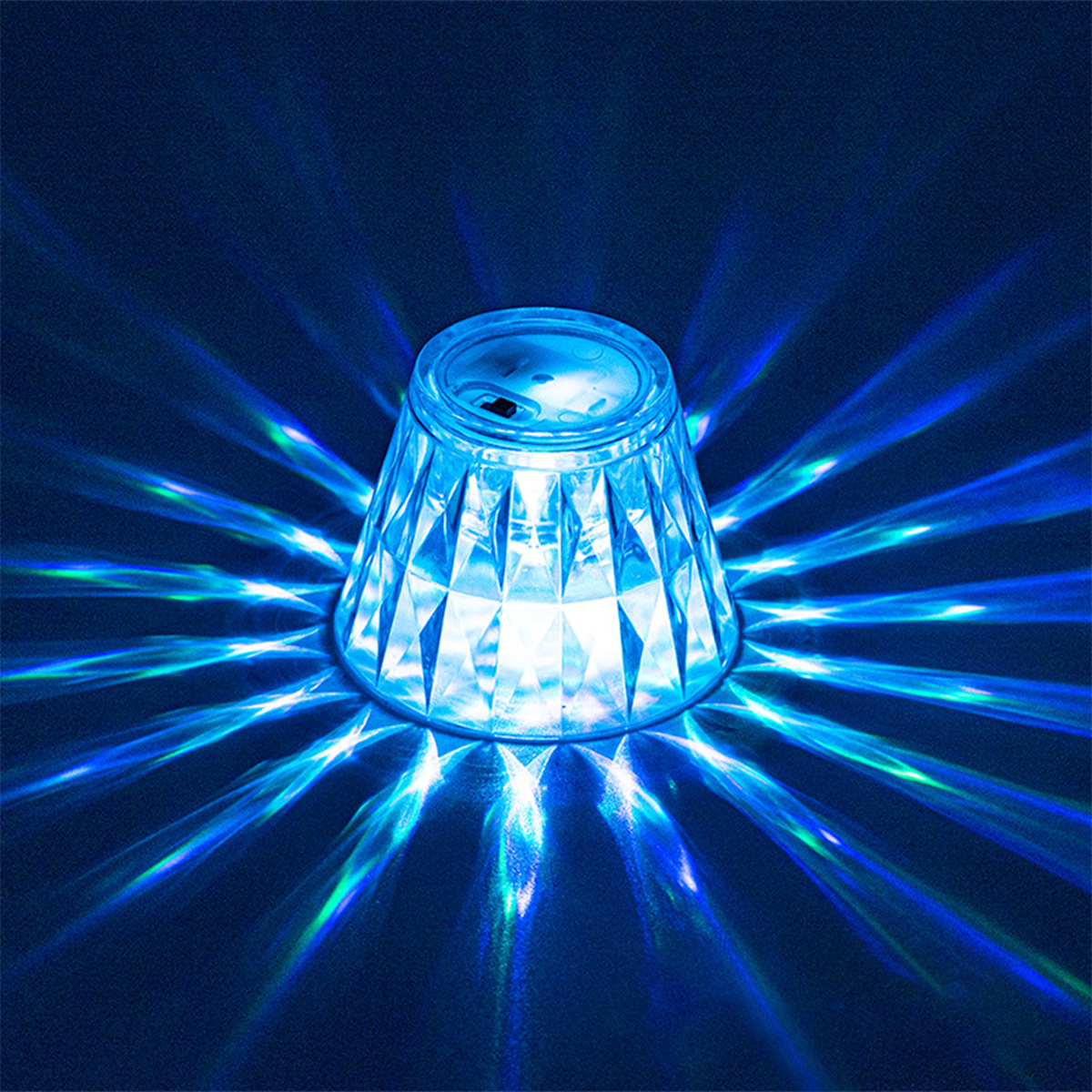 Ein blau beleuchtetes Glas. Blaue Lichtstrahlen strahlen von oben aus.