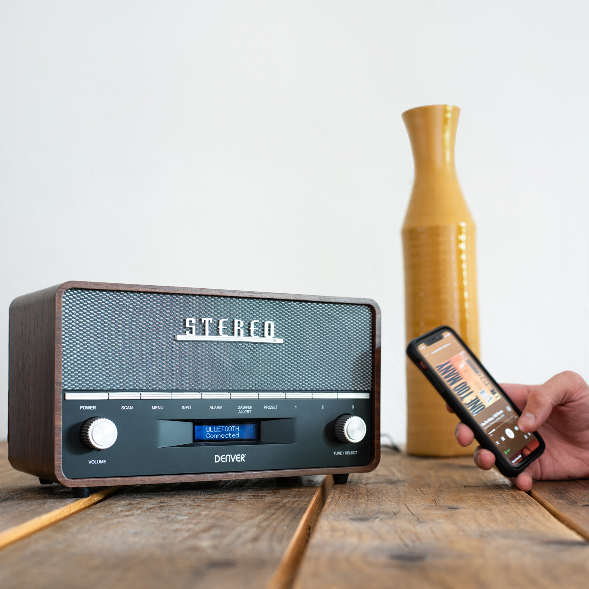 Radio w stylu retro z telefonem wyświetlającym aplikację.