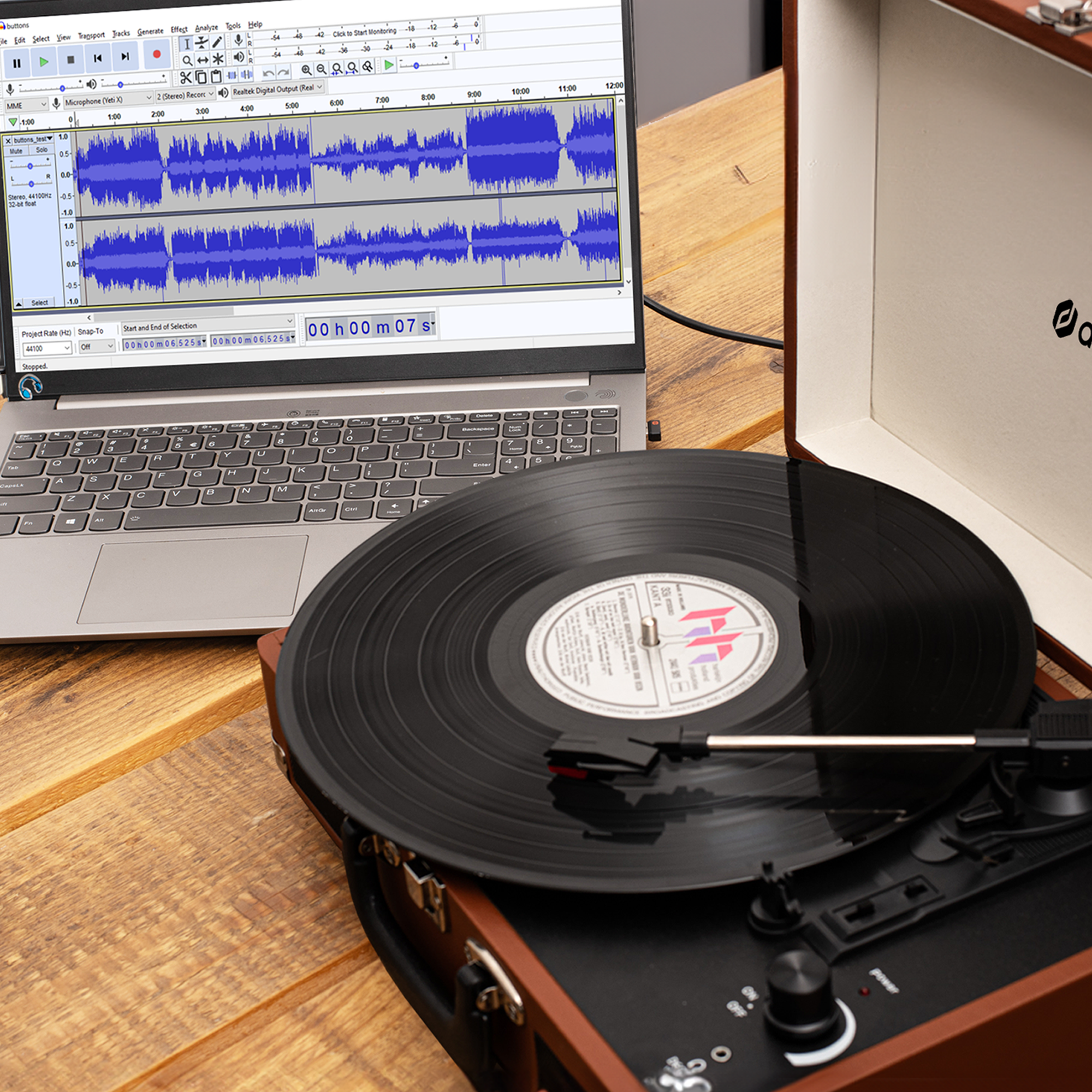 Laptop z interfejsem nagrywania i gramofon z płytą winylową.