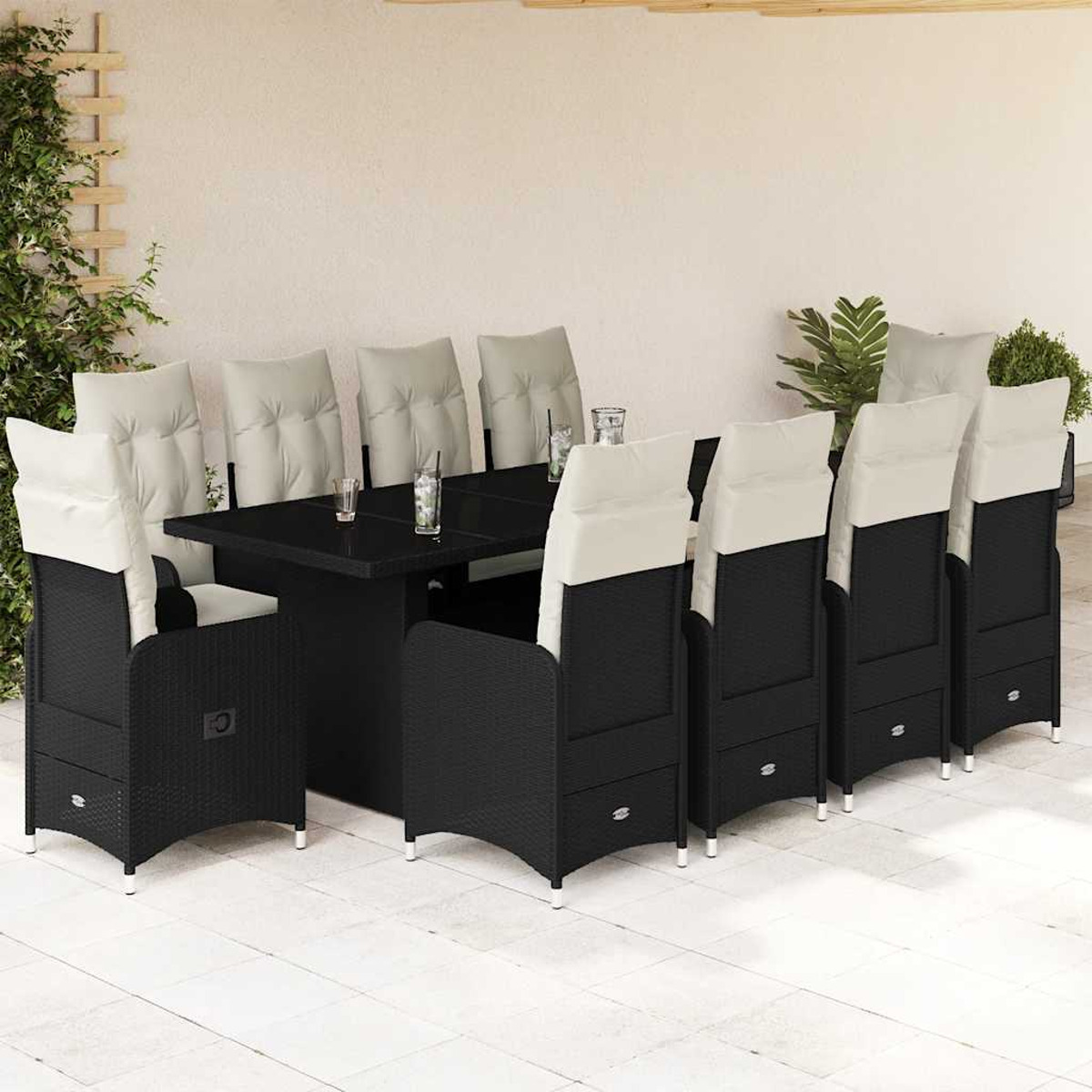 Set da pranzo all'aperto con tavolo nero e sedie con cuscini beige, su un patio bianco.