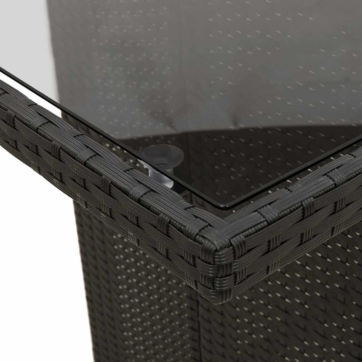 Primo piano di un angolo di tavolo nero intrecciato con piano in vetro.