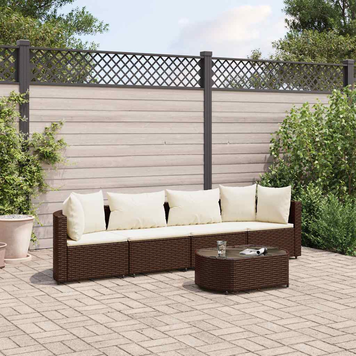 Outdoor-Sitzgruppe: braunes Korbmöbel-Sofa mit cremefarbenen Kissen und passendem Couchtisch.