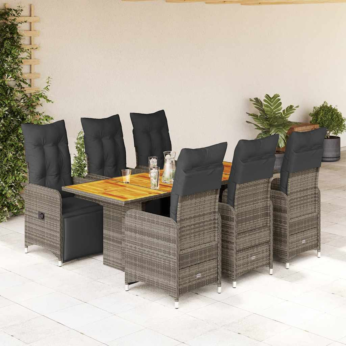 Un set da pranzo per patio con tavolo in legno e sedie nere, contro un muro chiaro.