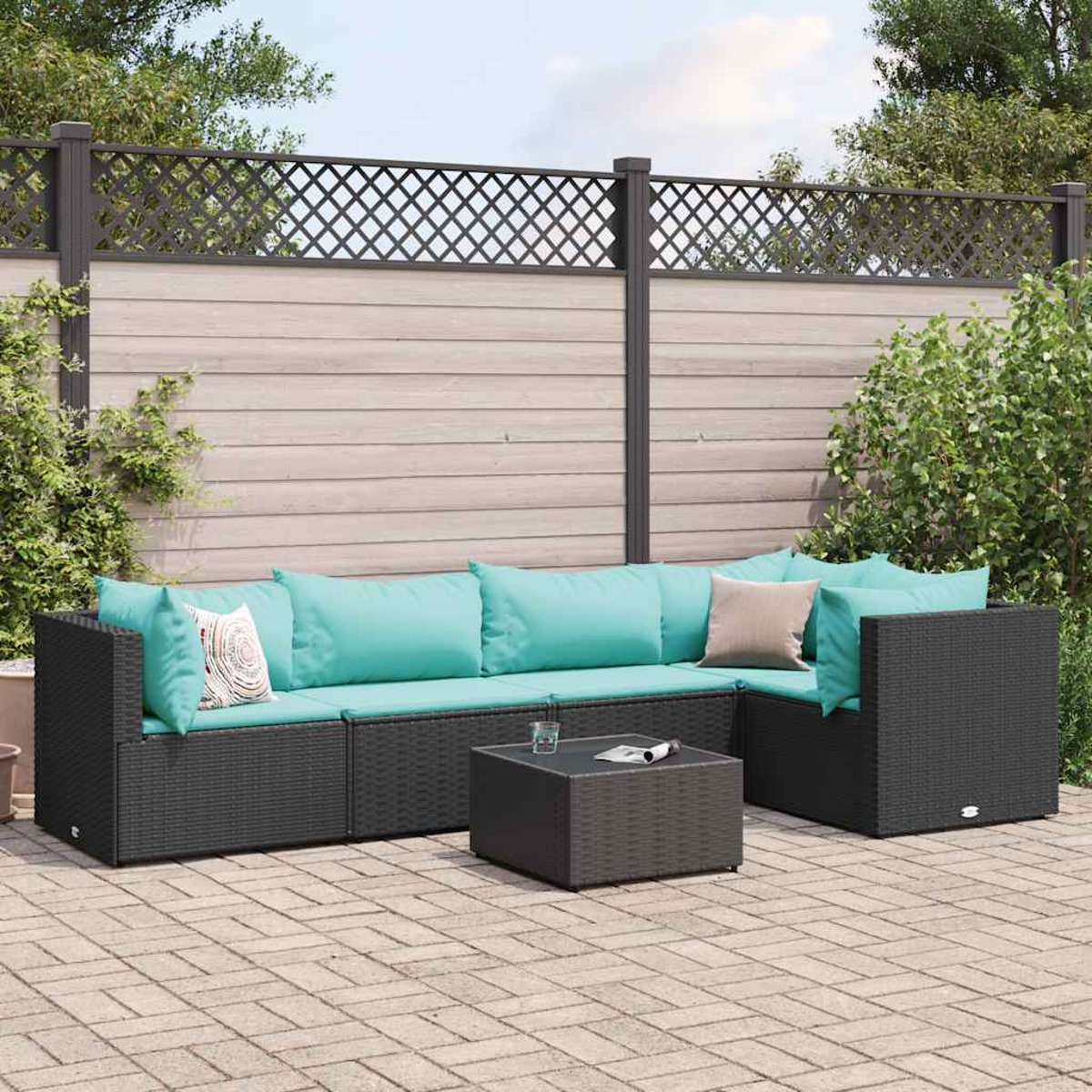 Set divano in rattan nero con cuscini acqua marina, su un patio.