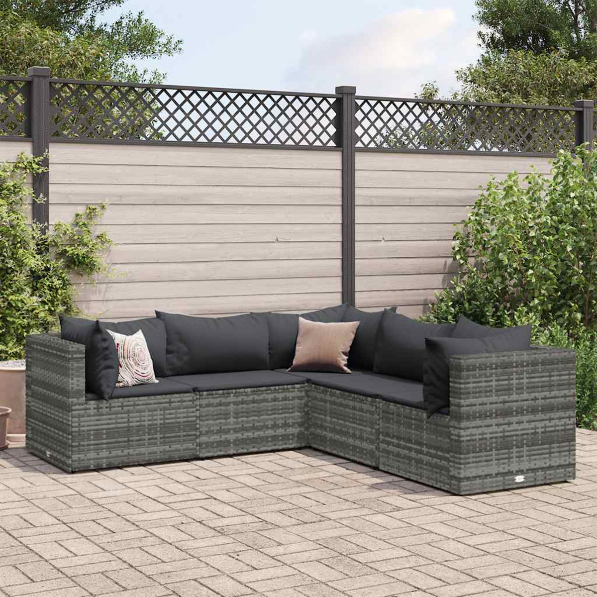 Graues Korbsessel-Ecksofa mit schwarzen Kissen, Ziegel-Terrasse.