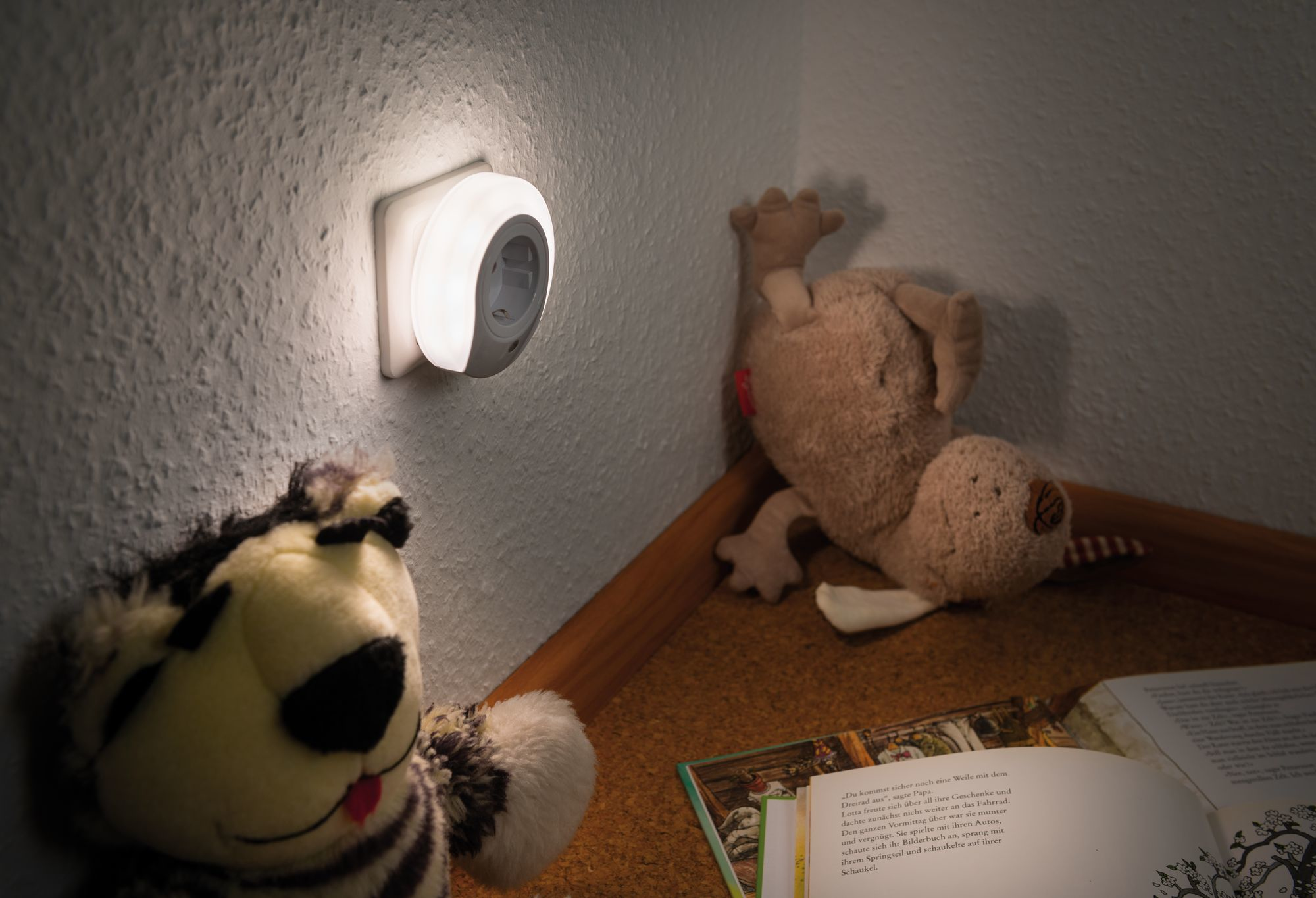 Luce notturna collegata alla parete. Peluche nelle vicinanze, in una stanza.