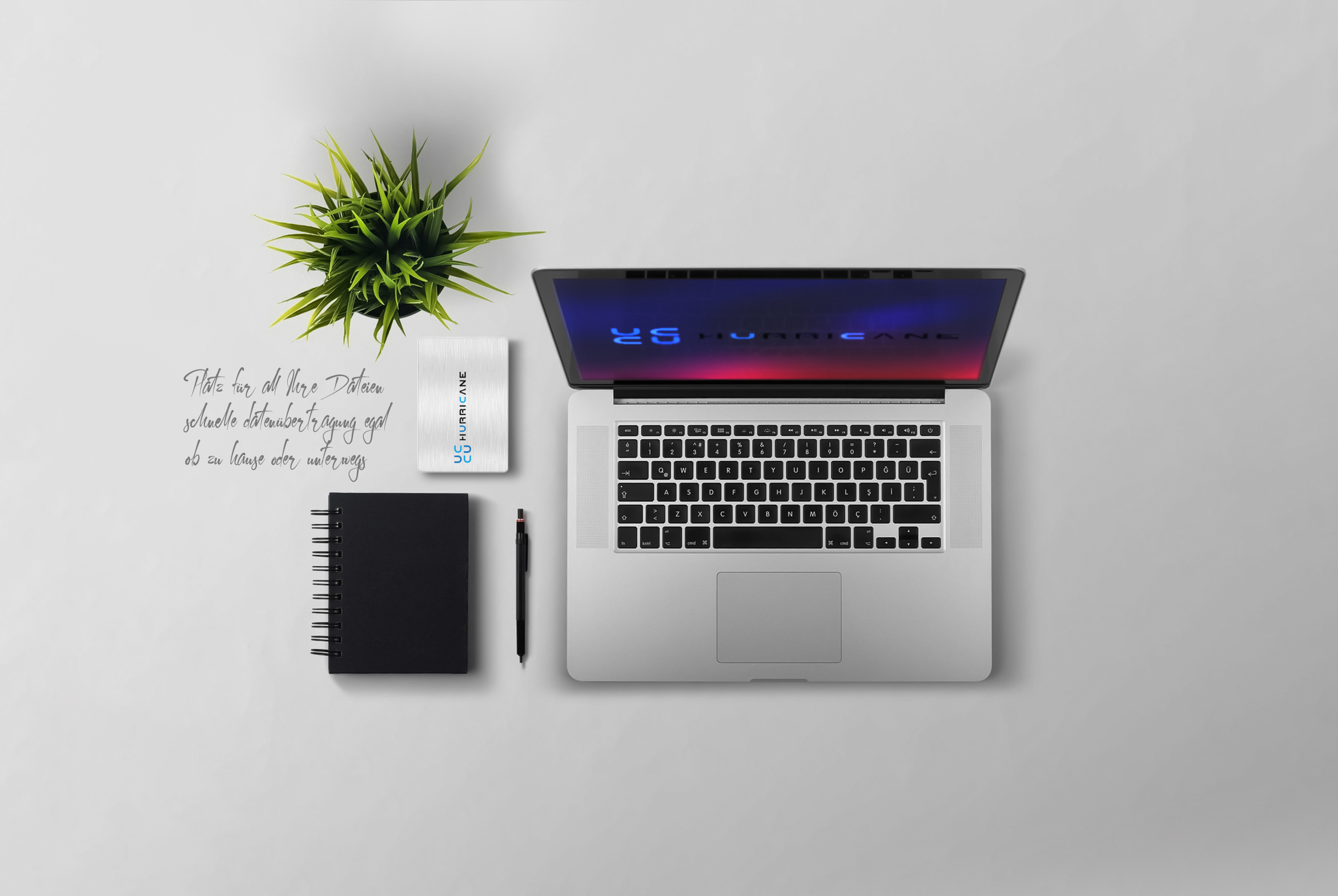 Laptop, Notizbuch, Stift und Pflanze auf weißer Oberfläche. Text auf Deutsch über Datensicherung.