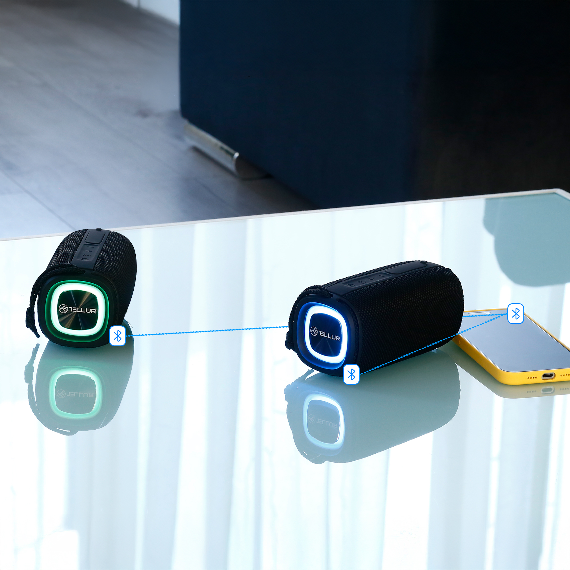 Dwa czarne głośniki i telefon z połączeniami bluetooth.