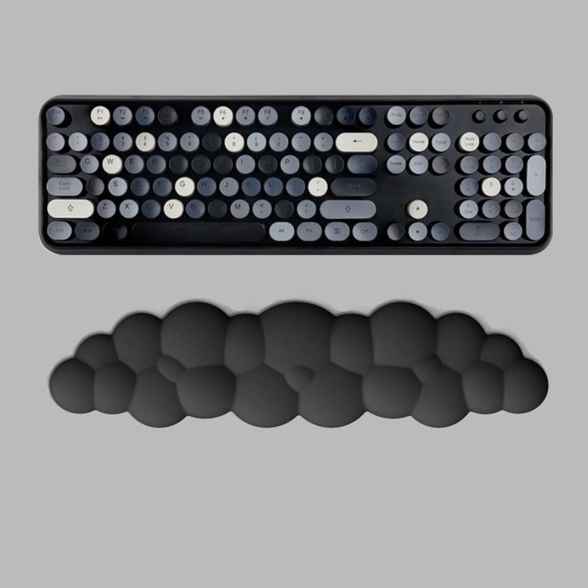 Un clavier noir avec des touches rondes et un repose-poignet noir. Les touches sont grises.