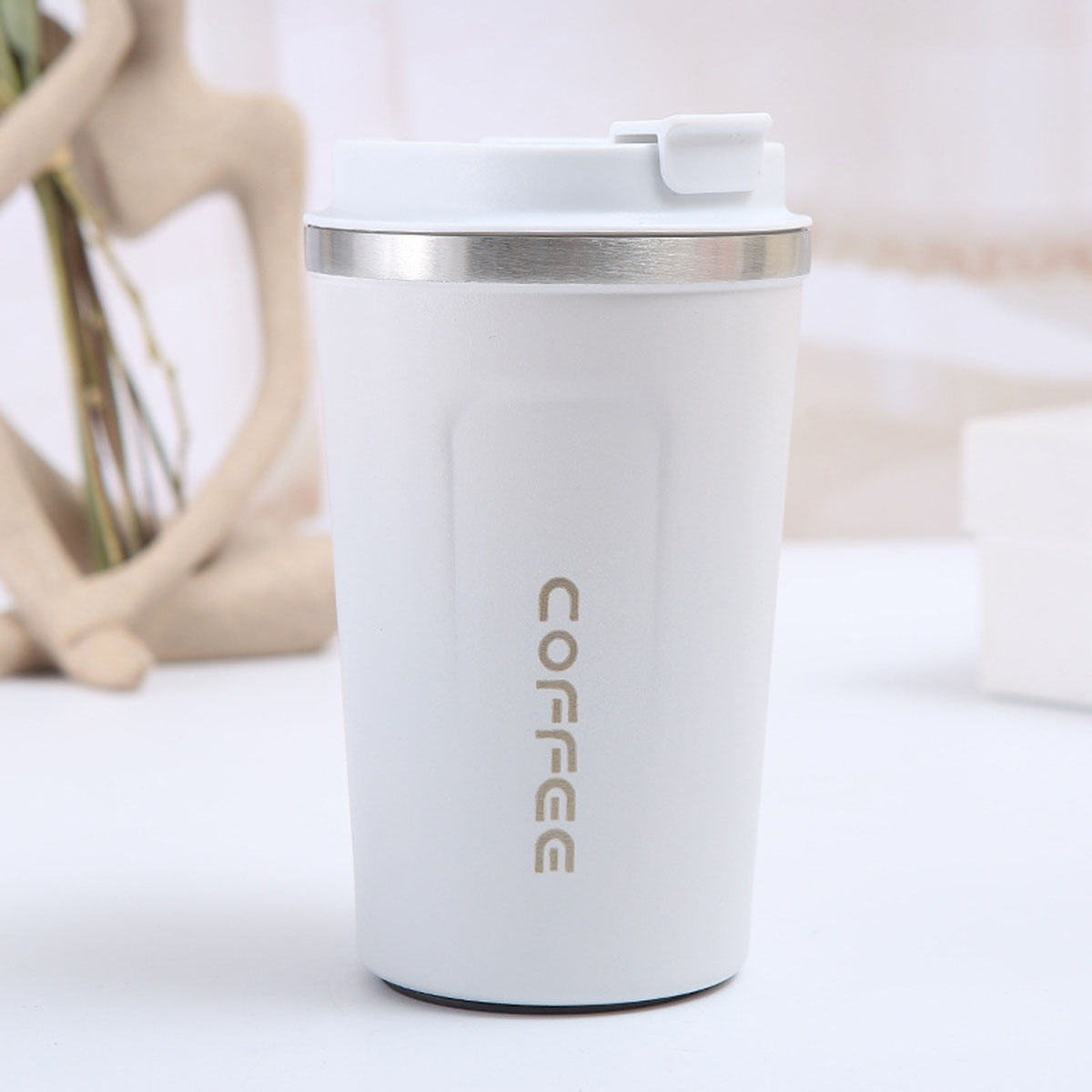 Ein weißer Kaffeebecher mit dem Aufdruck 'COFFEE'.