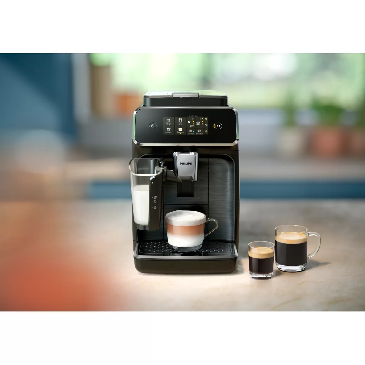 Eine schwarze Kaffeemaschine mit Milchbehälter, einer Tasse Kaffee und zwei kleinen Tassen.