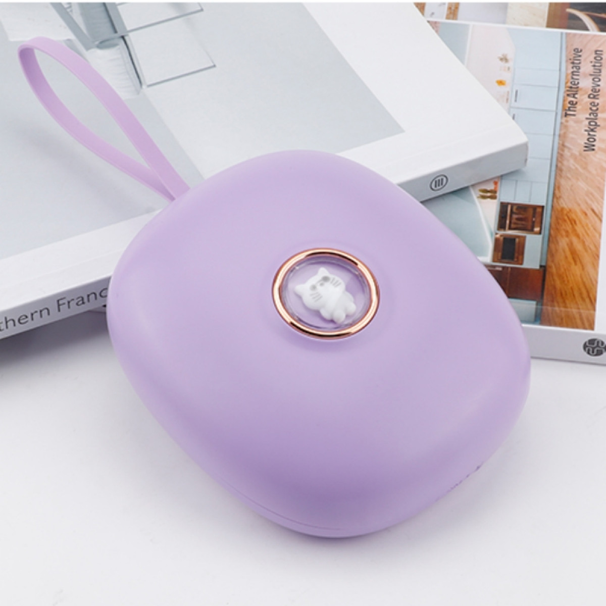 Een lavendelkleurige handwarmer met een kattenontwerp, gouden ringdetail en lus.