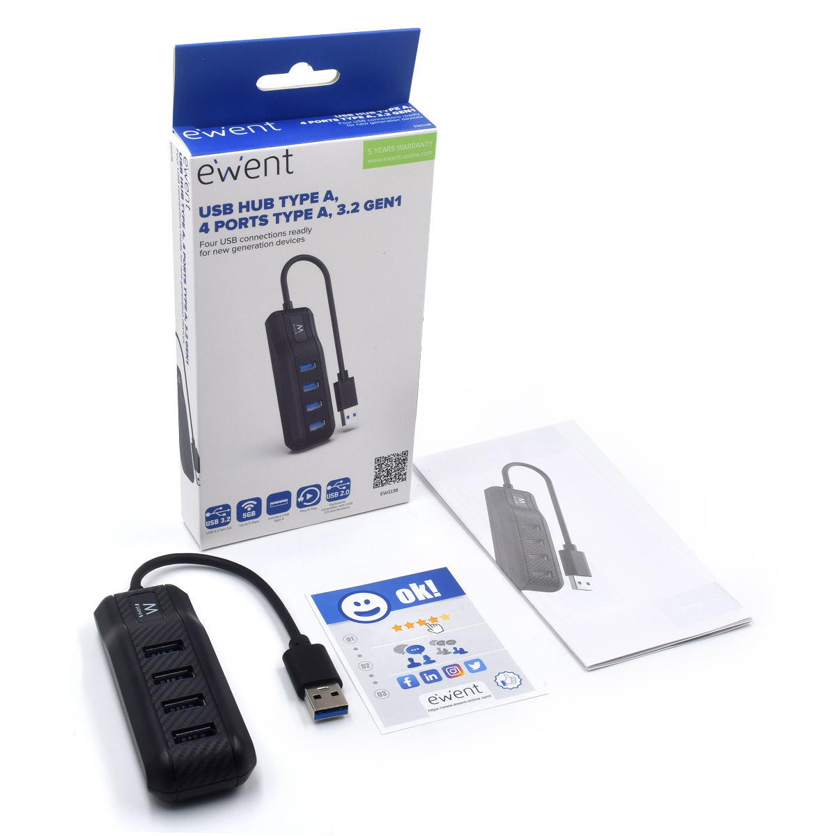 Hub USB con scatola, documenti e scheda su superficie bianca.