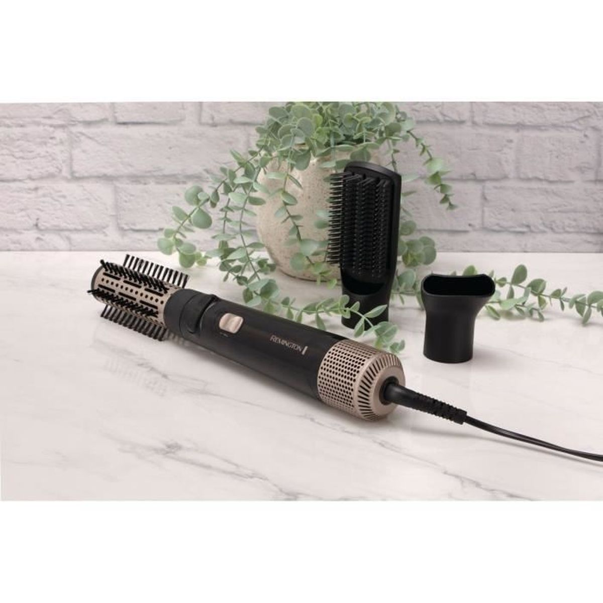 Narzędzia do stylizacji włosów na marmurowej powierzchni. Zawiera czarną szczotkę do suszenia, nakładkę szczotkową i dyszę, z zielenią.