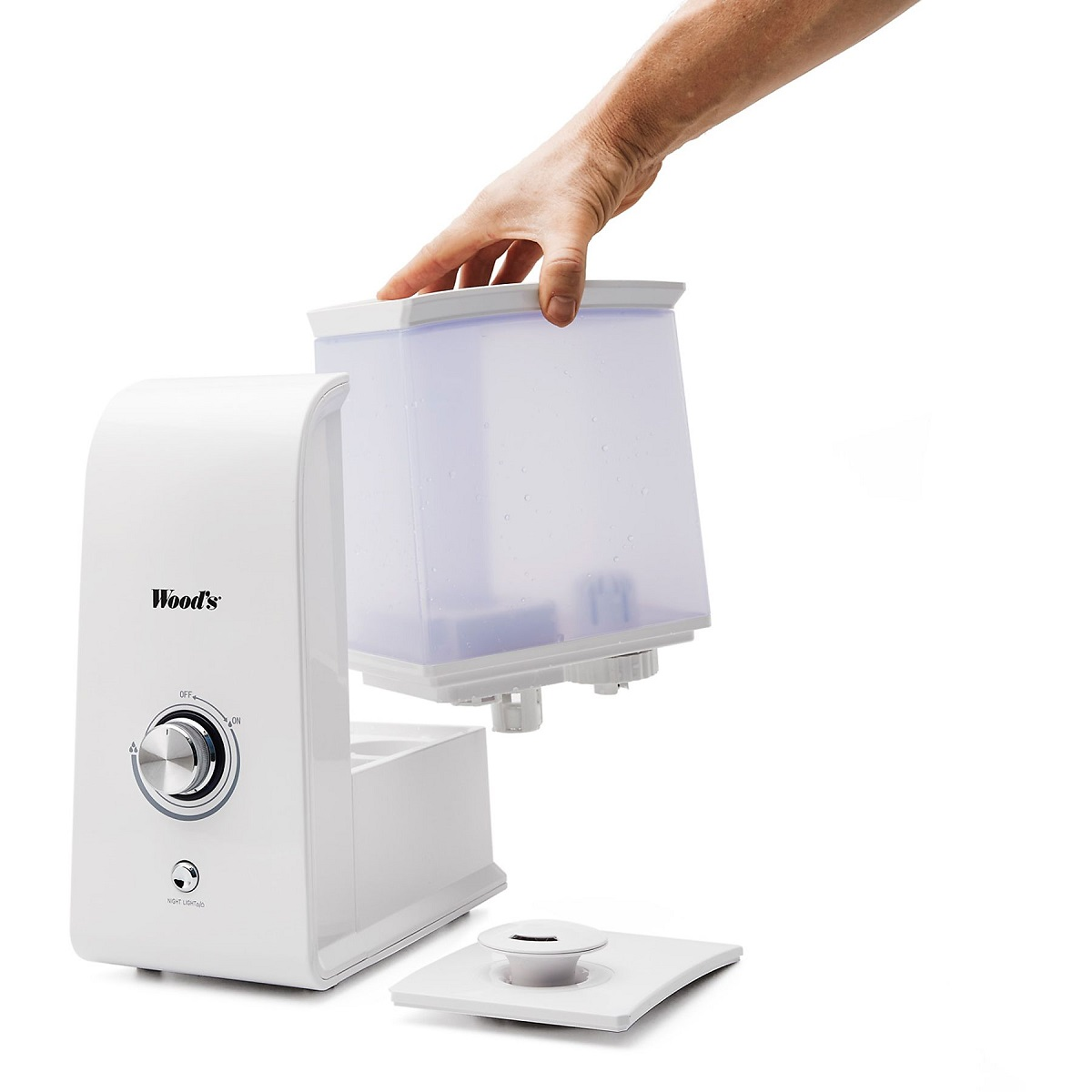 Ein weißer Luftbefeuchter mit transparentem Wassertank, der von einer Hand angehoben wird, auf weißem Grund.
