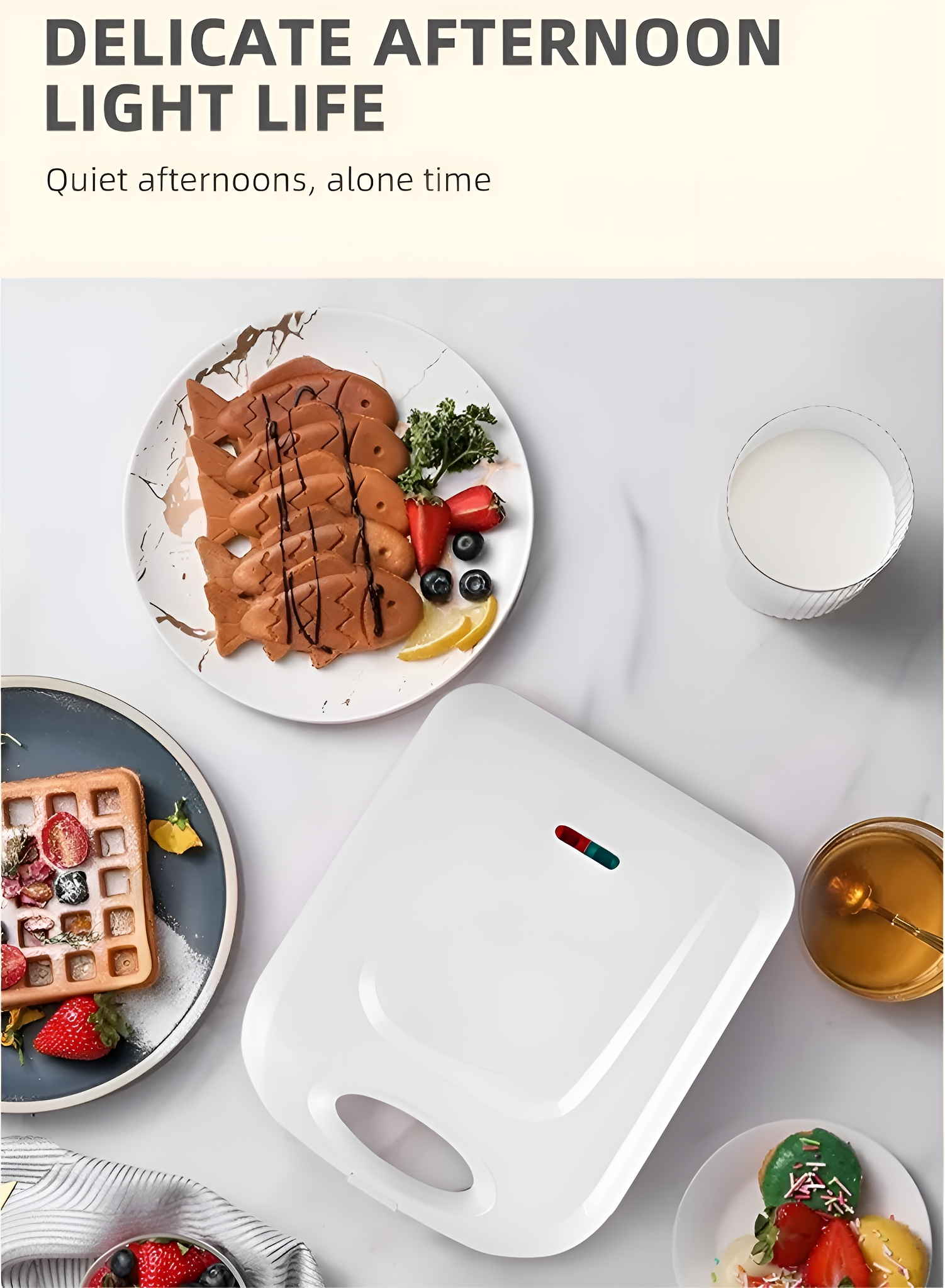 Ein weißer Waffeleisen, ein Teller mit Waffeln und fischförmige Pfannkuchen auf Marmor.