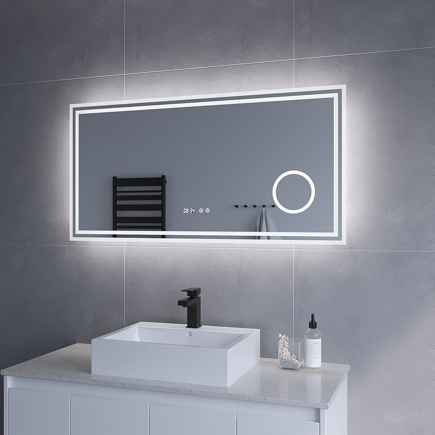 Ein rechteckiger Spiegel mit beleuchtetem Rand und Digitaluhr. Ein schwarzer Wasserhahn ist sichtbar.