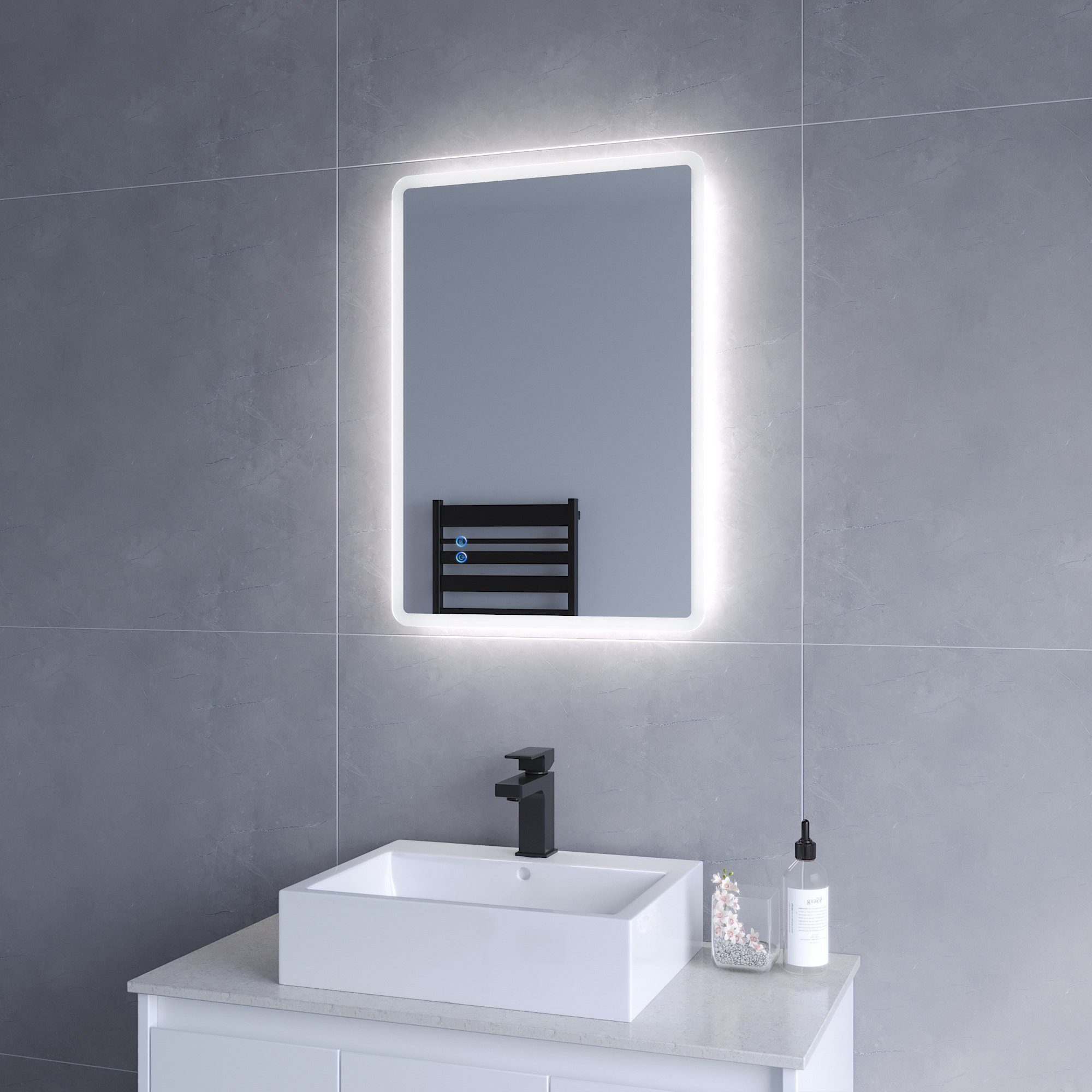 Modernes Badezimmer mit beleuchtetem rechteckigem Spiegel, schwarzem Wasserhahn und Accessoires.