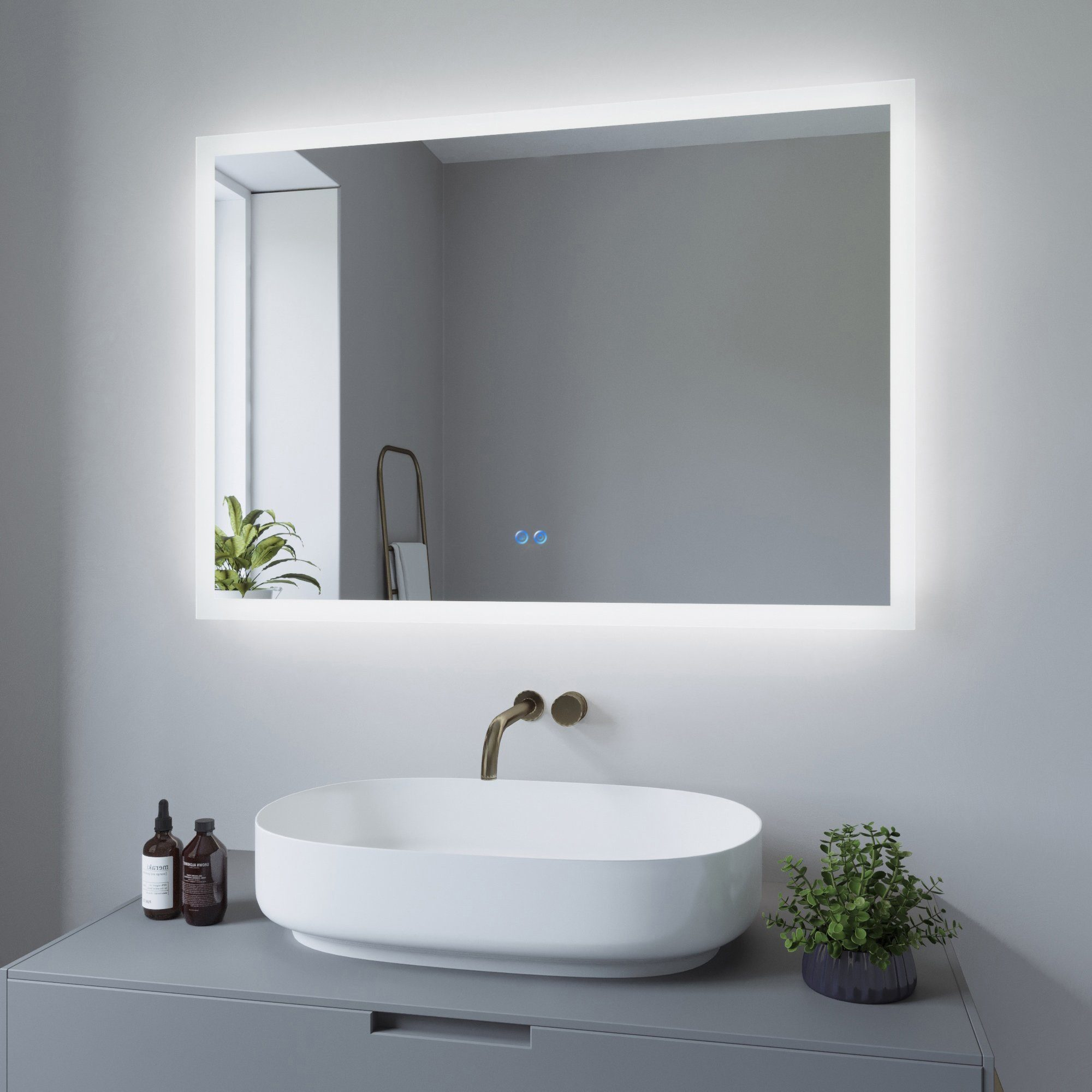 Modernes Badezimmer mit beleuchtetem Spiegel über einem weißen ovalen Waschbecken. Graue Wand.