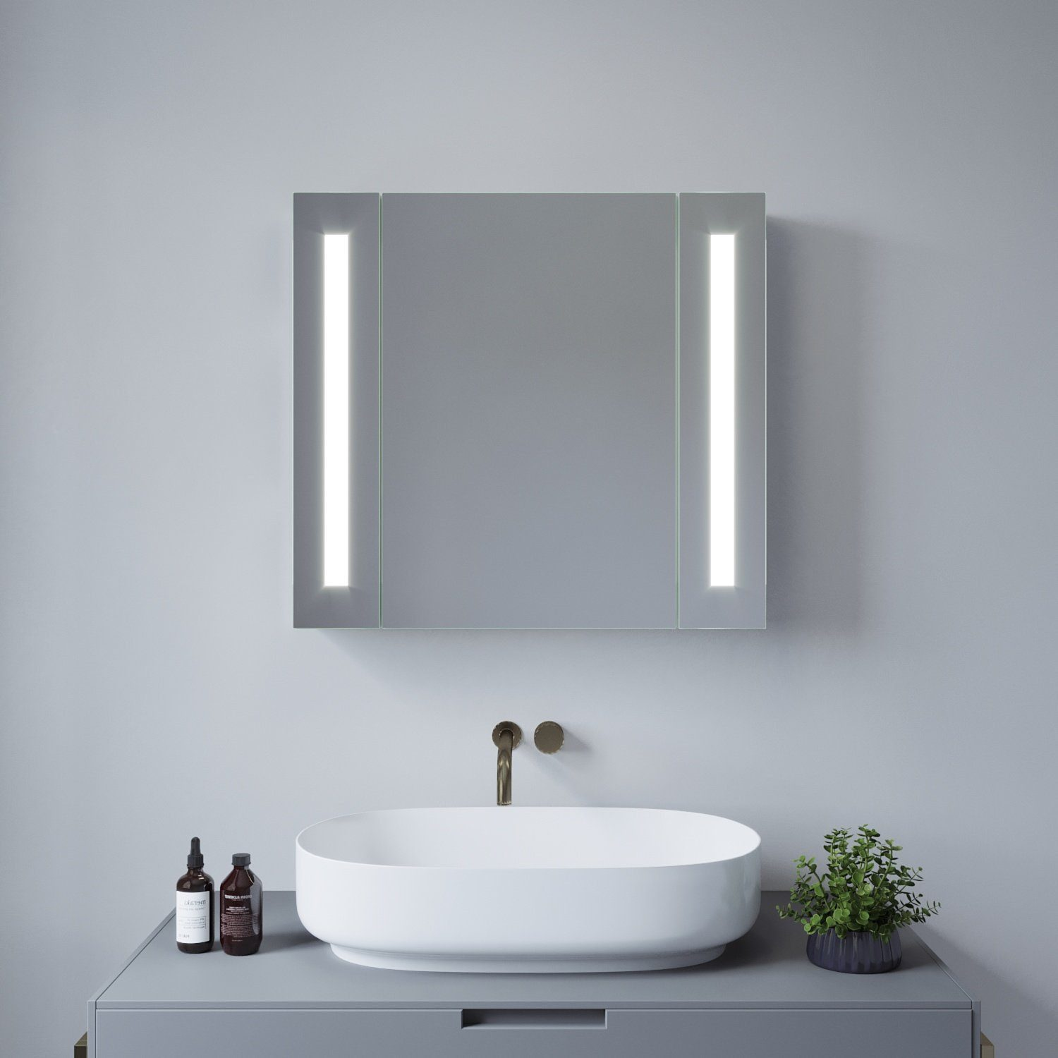 Ein modernes Badezimmer mit Spiegelschrank mit vertikalen Lichtern über einem weißen ovalen Waschbecken und einer kleinen Pflanze.
