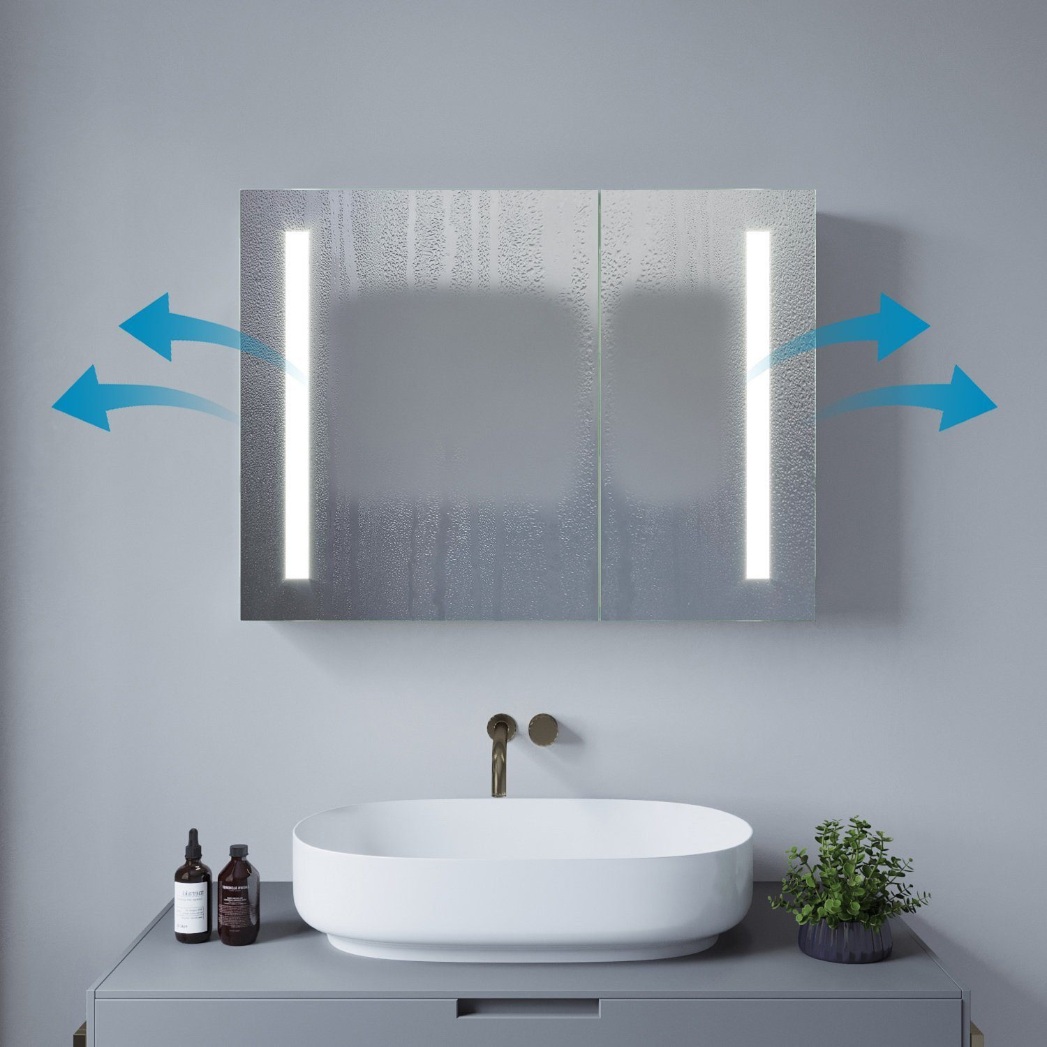 Badezimmerspiegel mit Beleuchtung. Ein Waschbecken und zwei Flaschen vor dem Spiegel.
