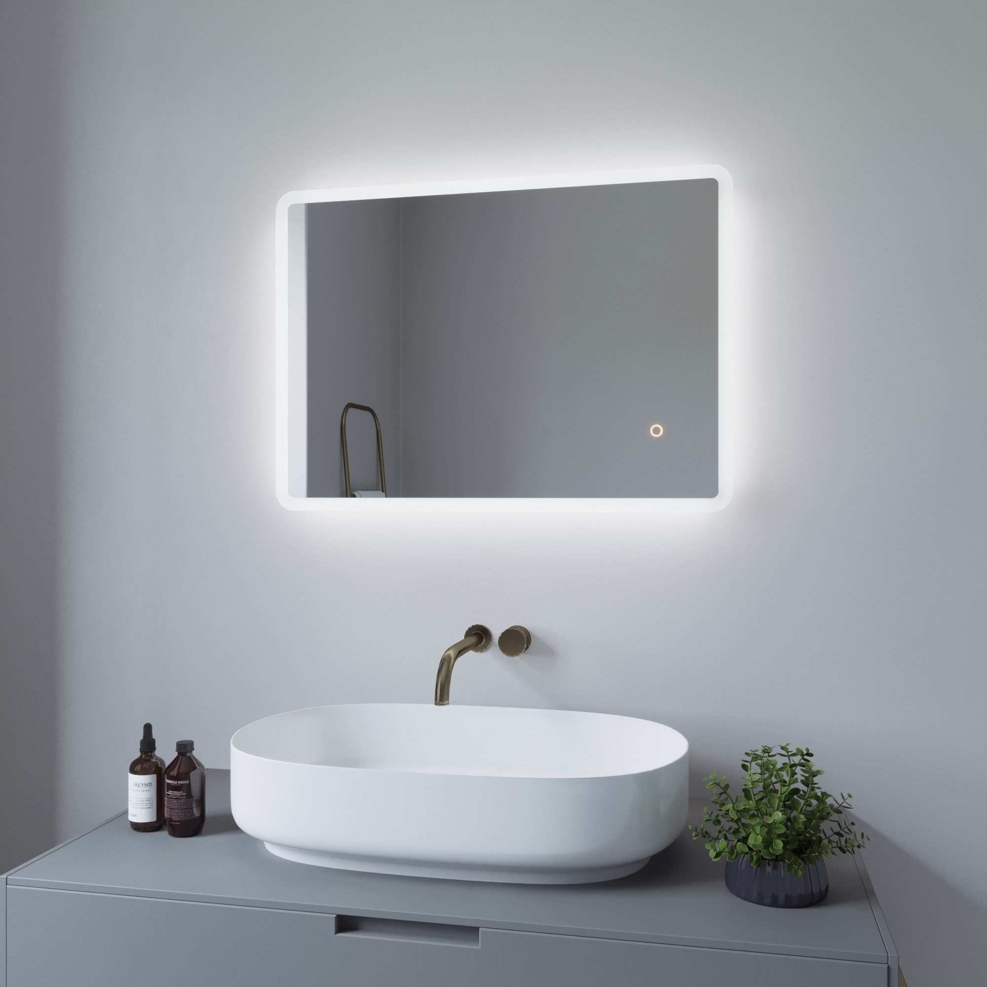 Badezimmer mit beleuchtetem Spiegel über einem Waschbecken.