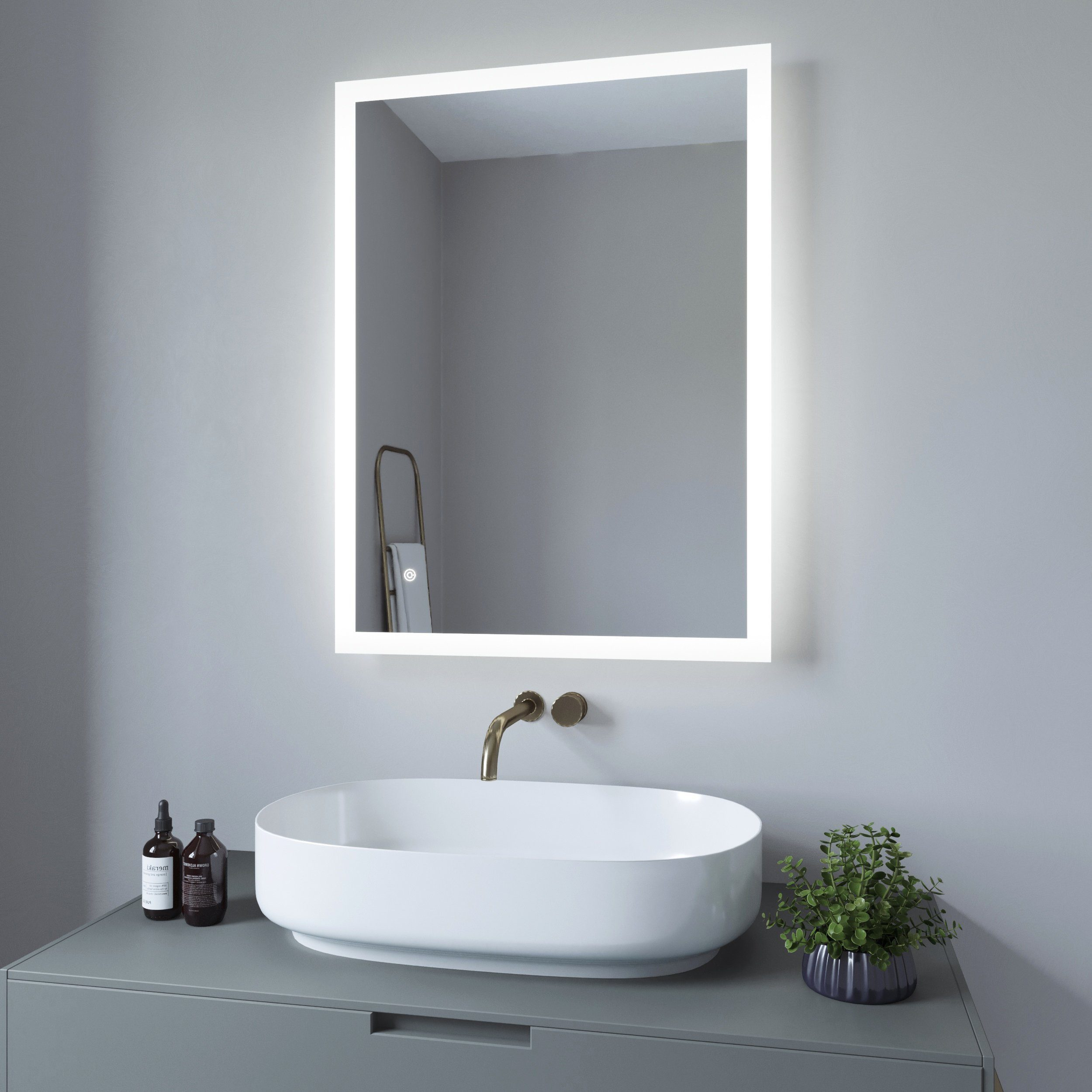 Badezimmer mit beleuchtetem Spiegel, Waschbecken und Pflanze. Graue Wände und Schrank. Minimalistisches Design.