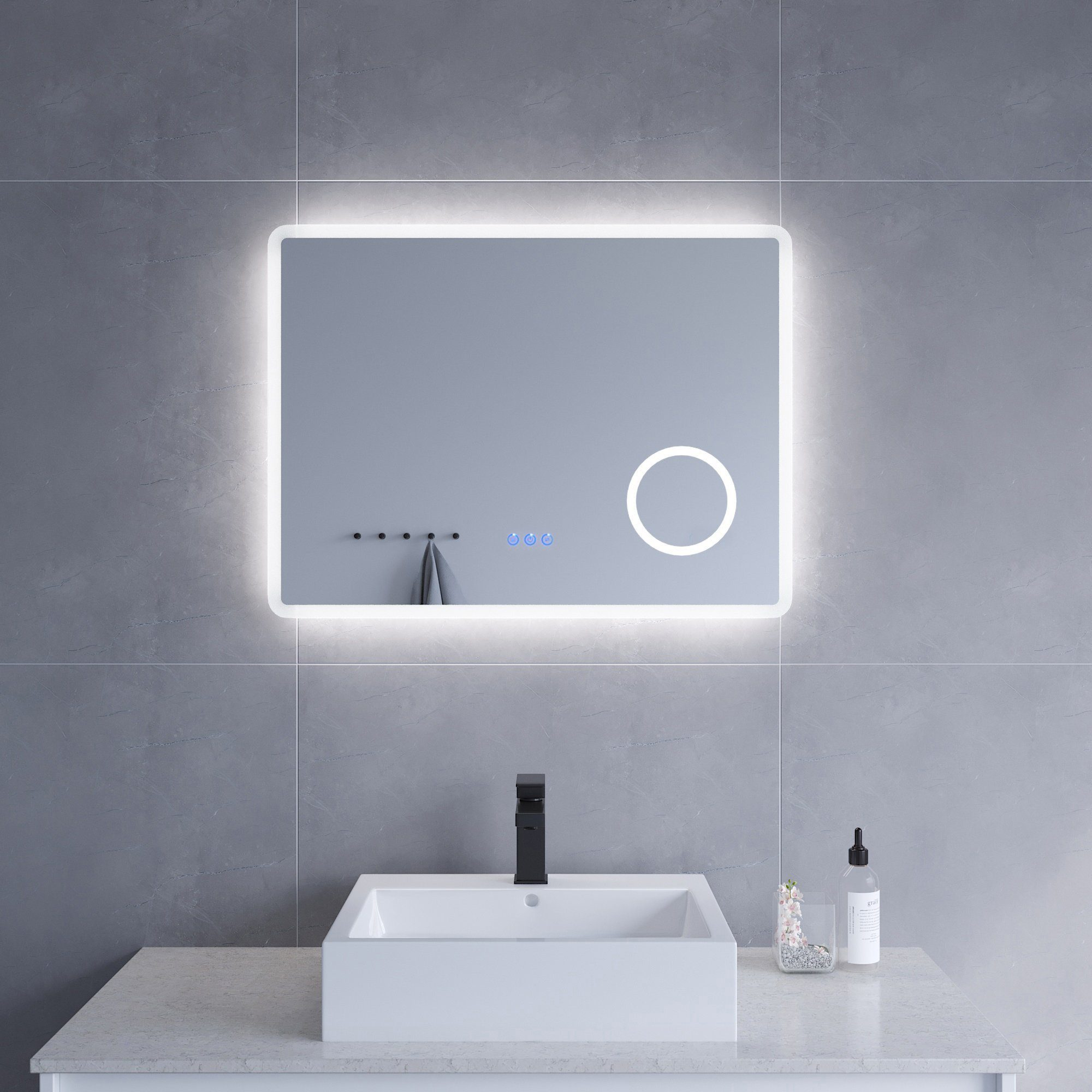 Modernes Badezimmer mit beleuchtetem Spiegel, Waschbecken und grauer Wand. Der Spiegel hat ein LED-Licht.