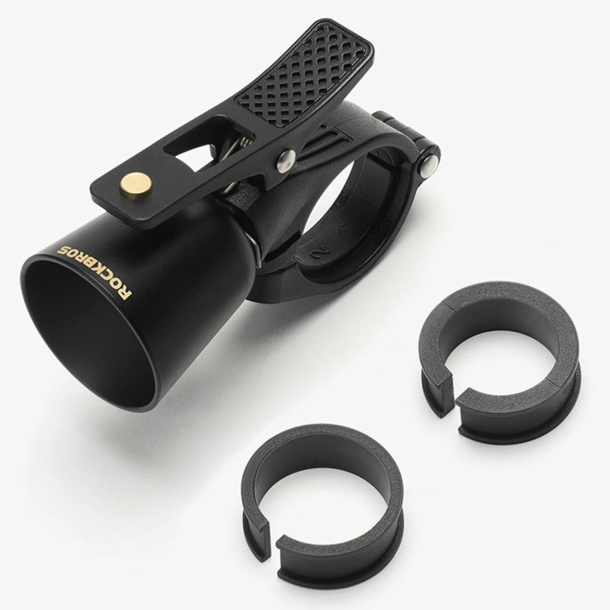 Czarny dzwonek rowerowy z zaciskiem i dwoma gumowymi pierścieniami na białym tle.