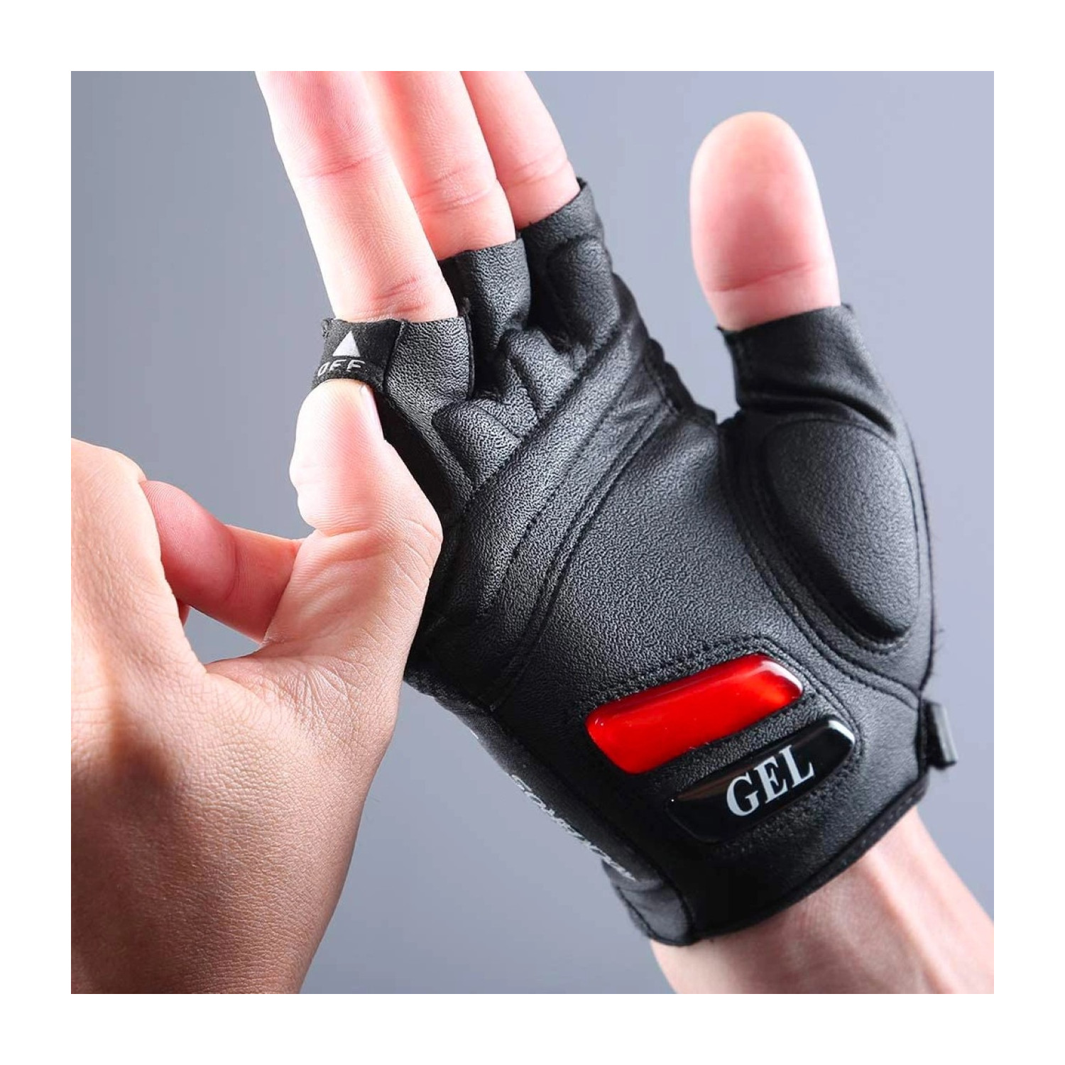 Eine Person trägt einen schwarzen Fahrradhandschuh mit einem rot-schwarzen Gel-Pad. Der Handschuh ist an einer Hand.