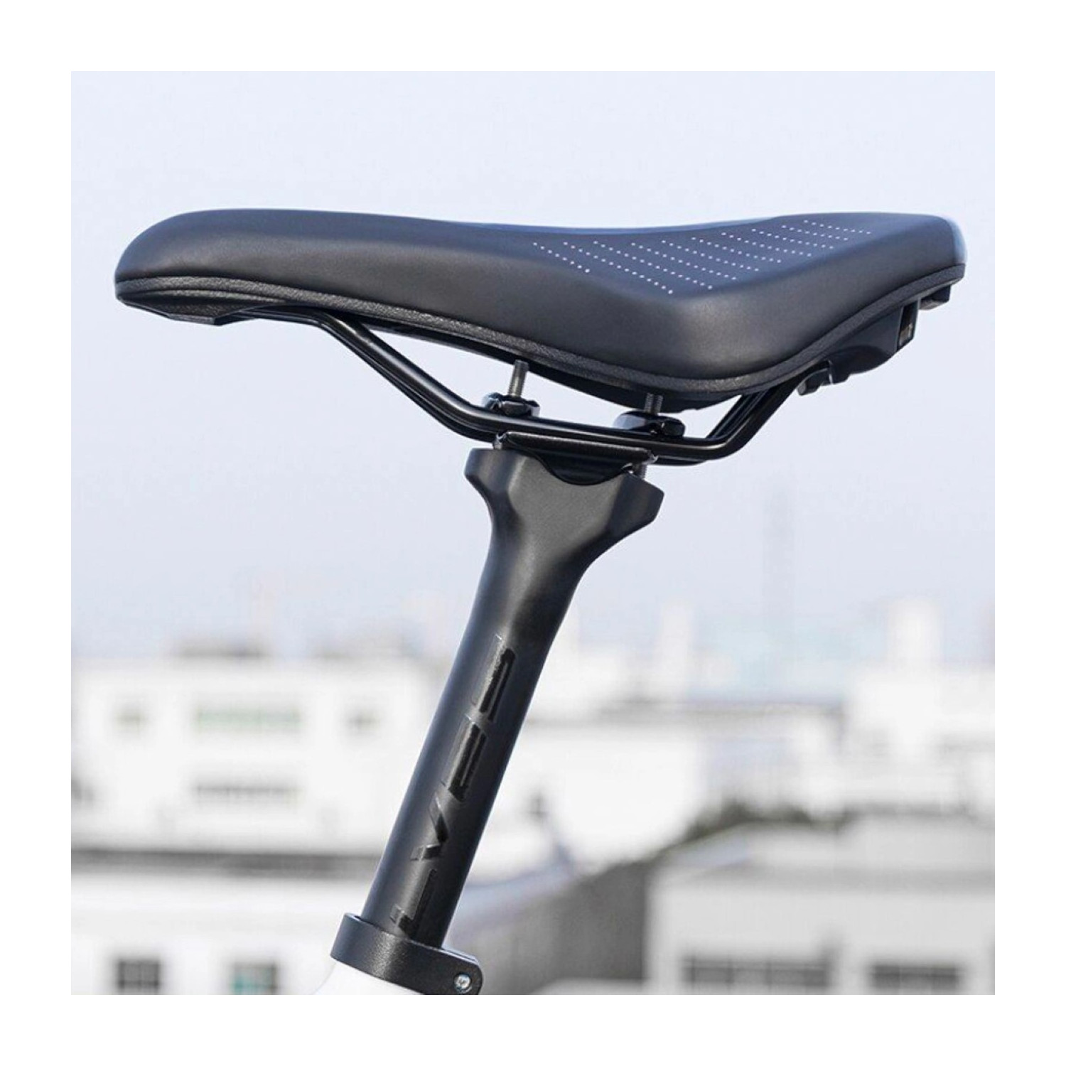 Czarne siodełko rowerowe z białymi kropkami i czarną sztycą na białym tle.