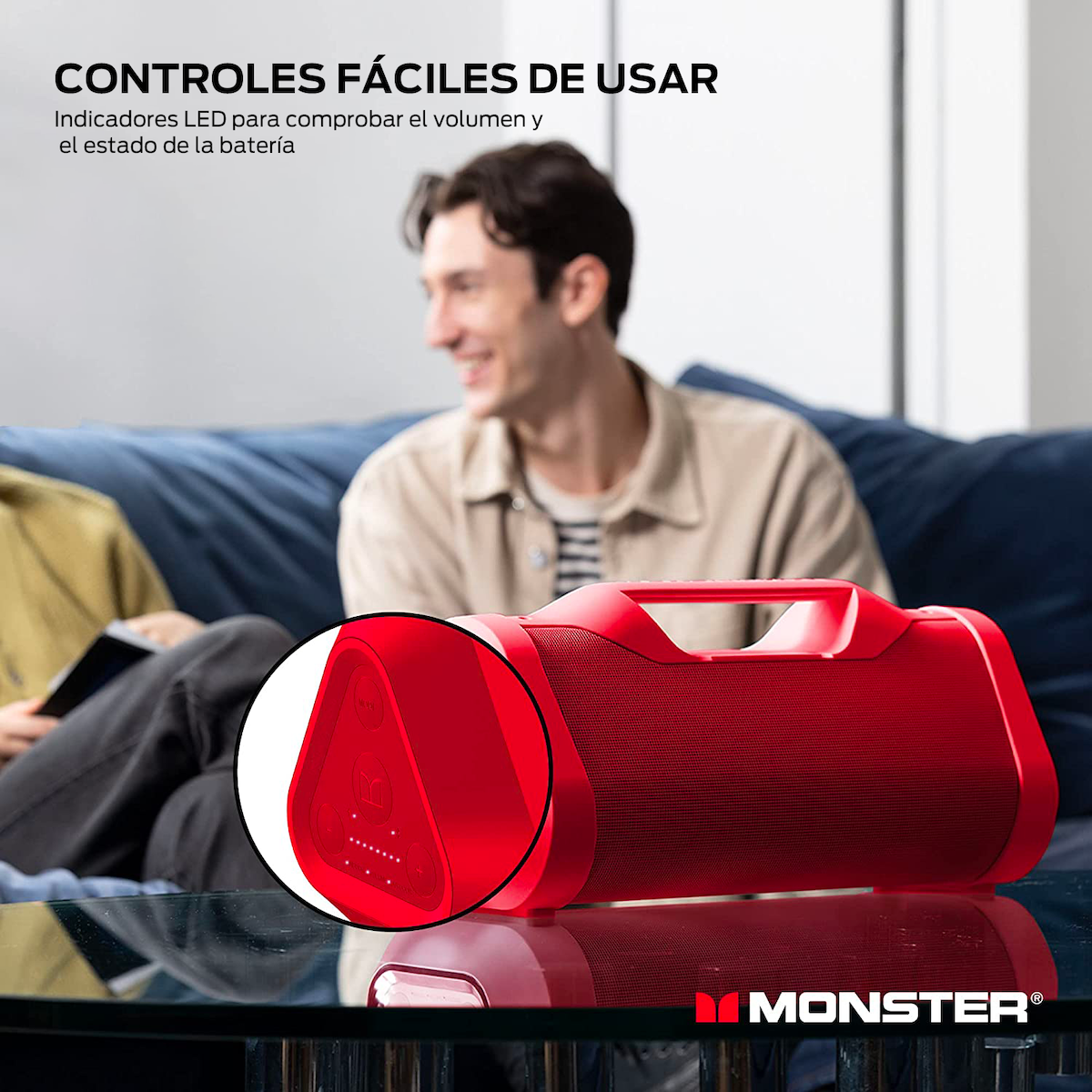 Un altavoz rojo con controles en una mesa de cristal, personas en el fondo.