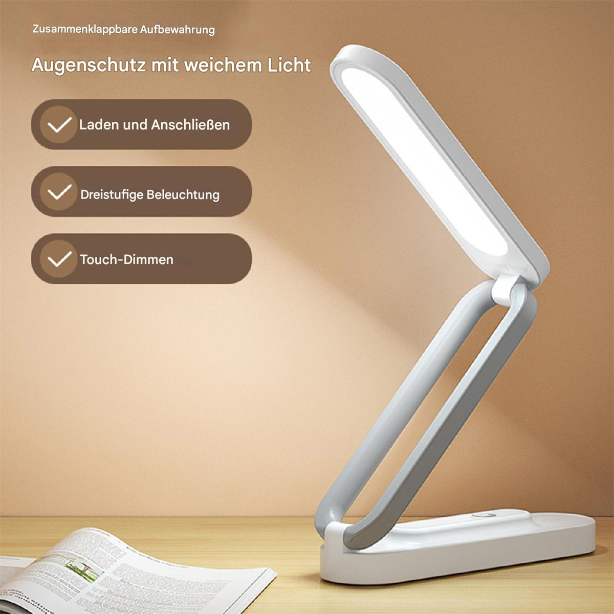 Faltbare Schreibtischlampe mit weißem Licht. Grauer Rahmen, weißer Sockel. Produktinfo und offenes Buch im Hintergrund.