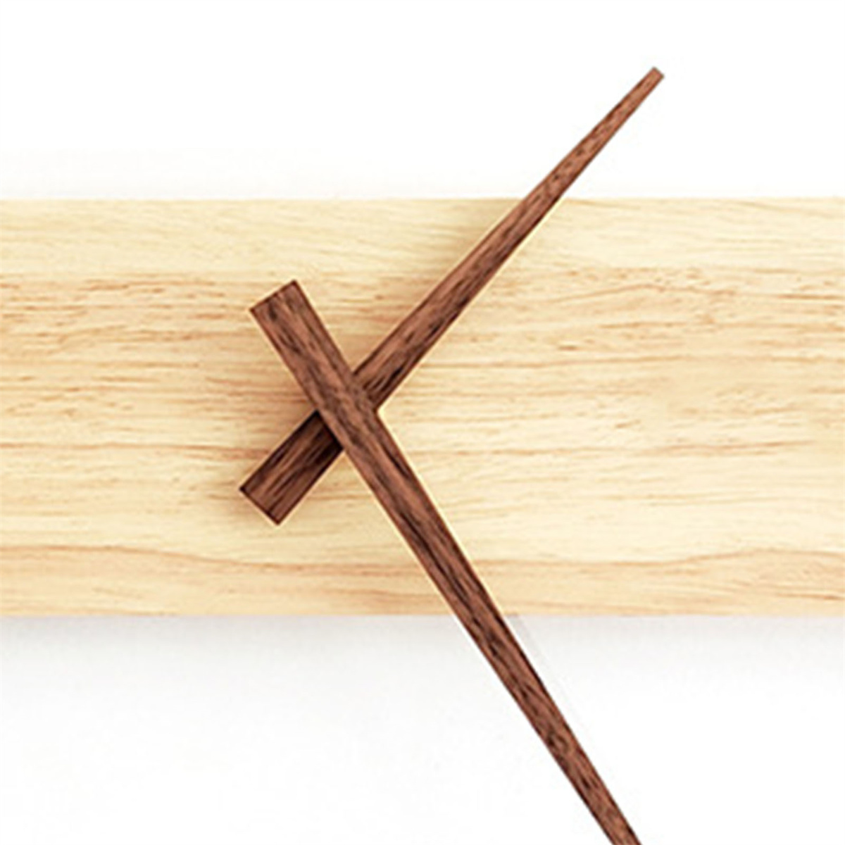 Holzuhr mit dunkelbraunen Holzzeigern. Die Uhr ist auf einer hellfarbigen Holzplatte montiert.