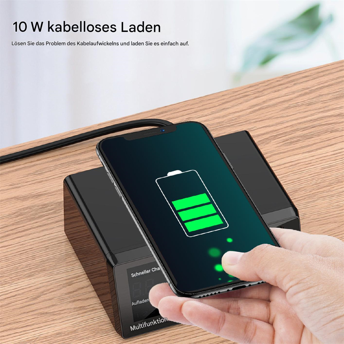 Ein Telefon wird auf einem schwarzen kabellosen Ladegerät geladen; eine Hand berührt das Telefon.