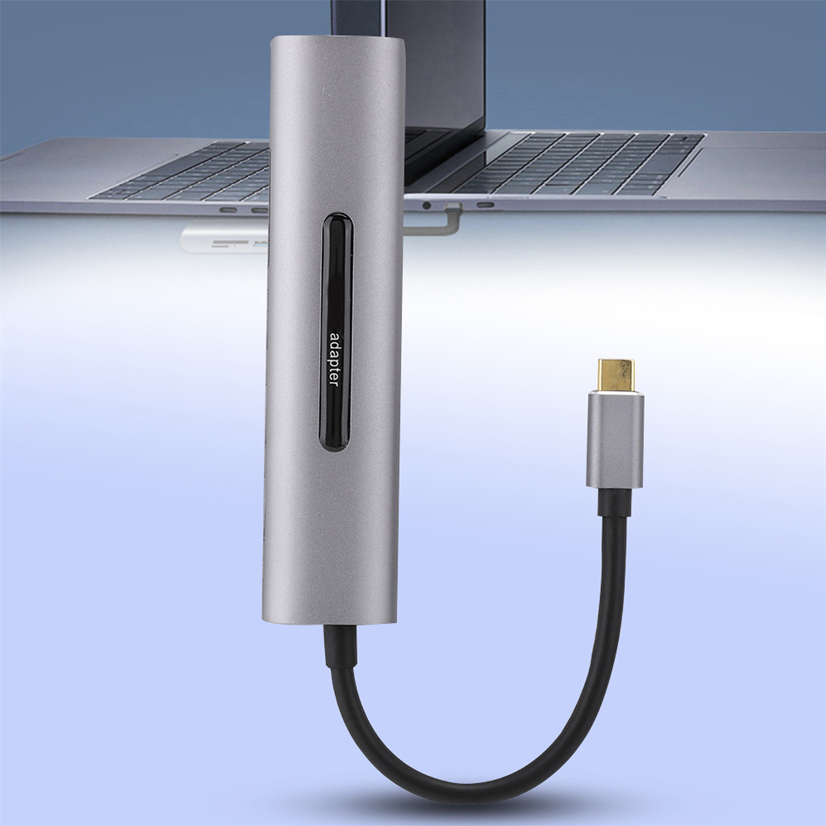 Silberner Adapter, an Laptop und USB-C-Kabel angeschlossen. Blauer und hellblauer Farbverlauf.
