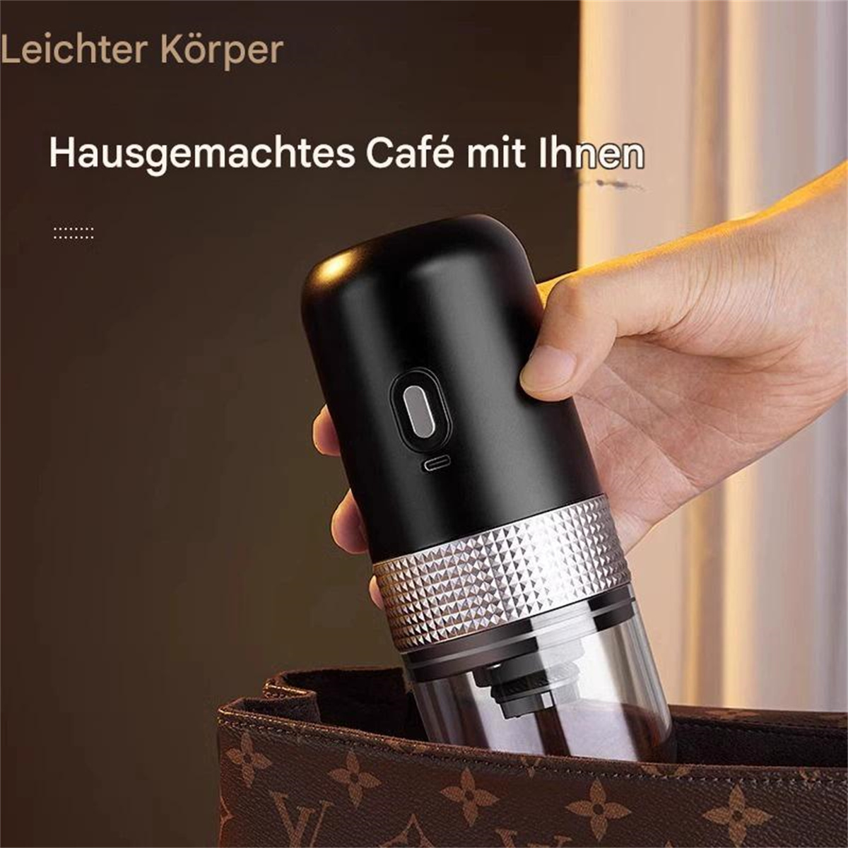 Schwarzer tragbarer Kaffeebereiter mit silbernem Band und Glasbehälter, gehalten von einer Hand.