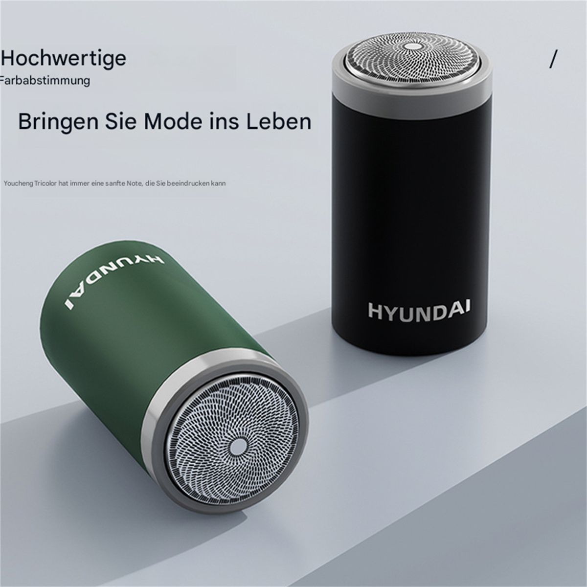 Zwei elektrische Rasierer, grün und schwarz, mit dem Markennamen HYUNDAI, auf grauer Oberfläche.