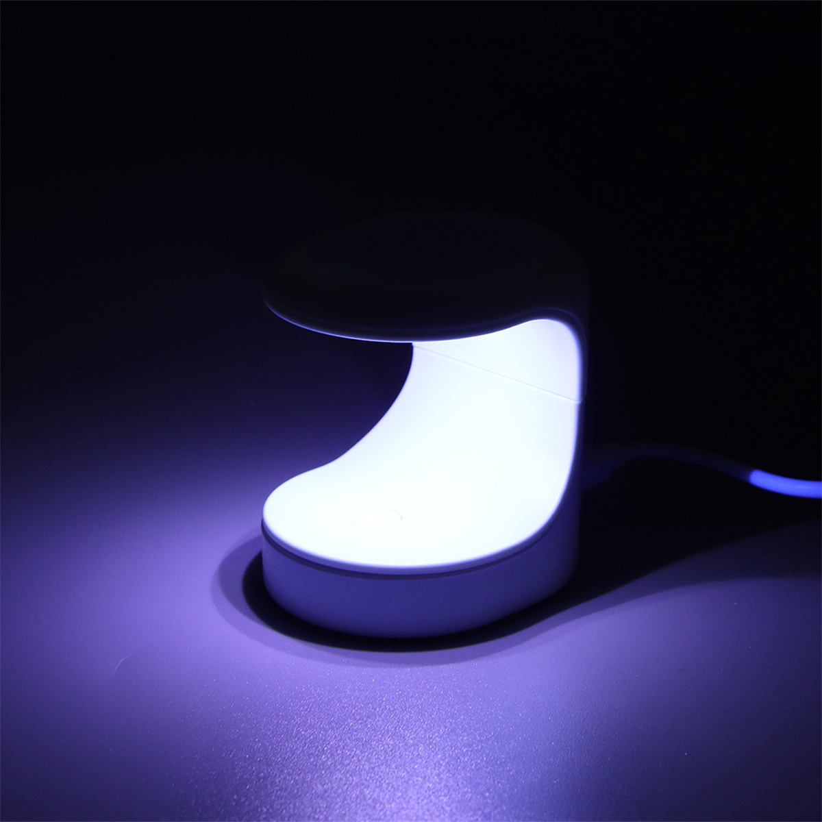 UV-LED-Nagellampe, weiß mit gewölbter Oberseite. Sie leuchtet violett.