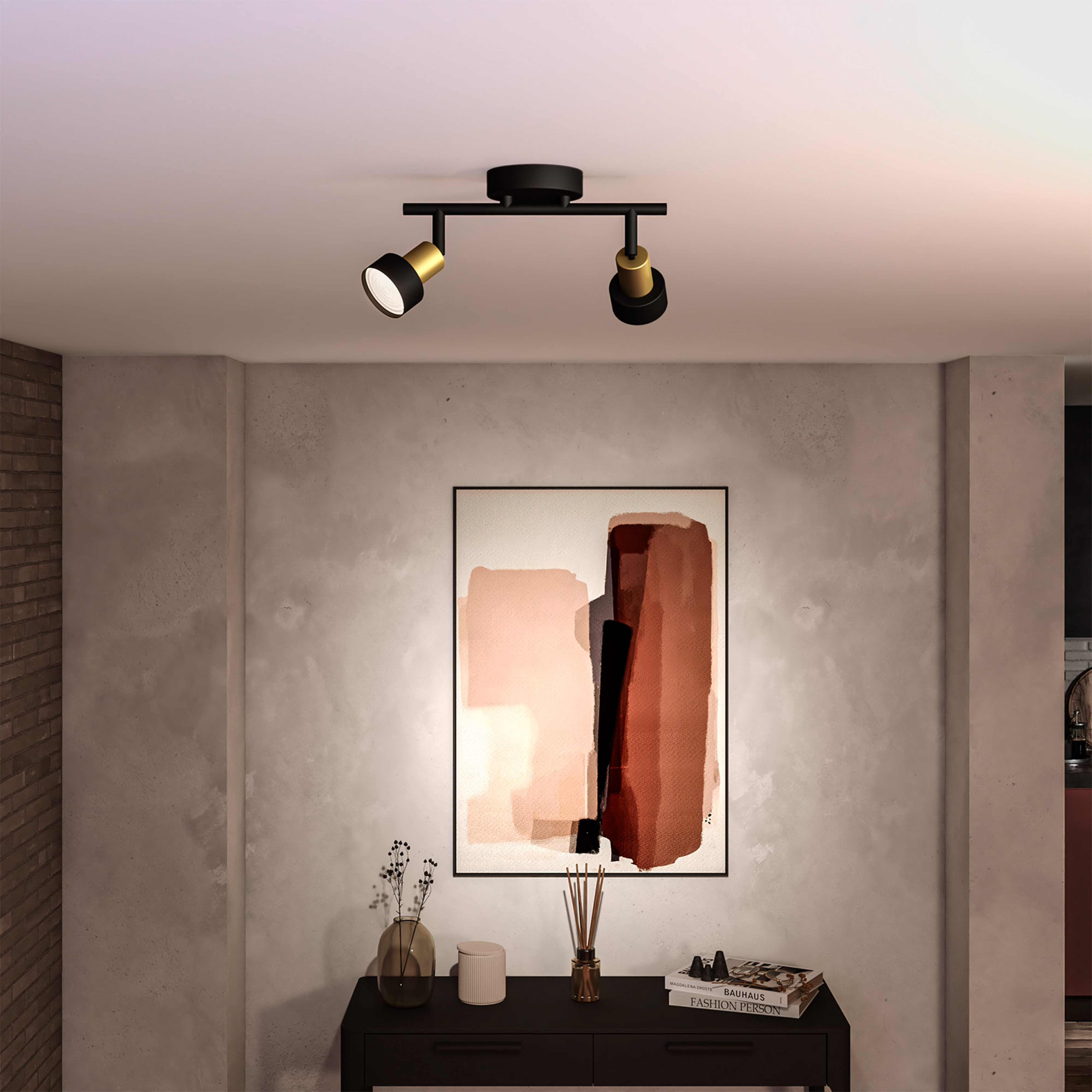 Plafond met zwarte en gouden spots, kunstwerk en tafel met decoratie.