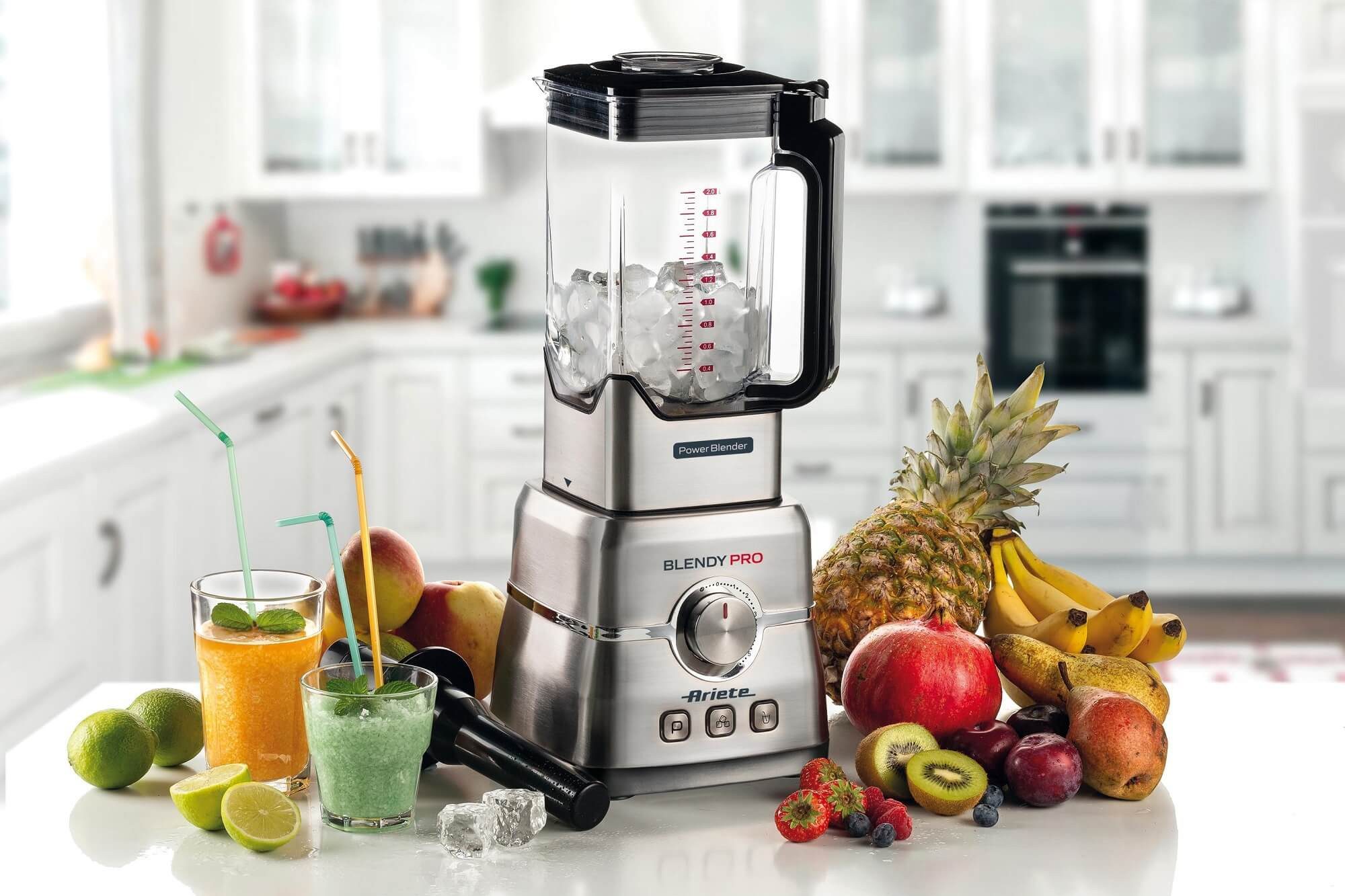 Frullatore con ghiaccio e frutta su un tavolo, cucina sullo sfondo.