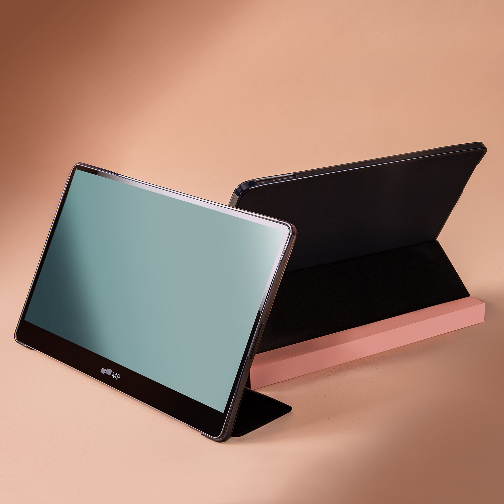 Zwei Tablets auf rosa Sockel. Eines offen mit Bildschirm, das andere geschlossen mit schwarzer Hülle.