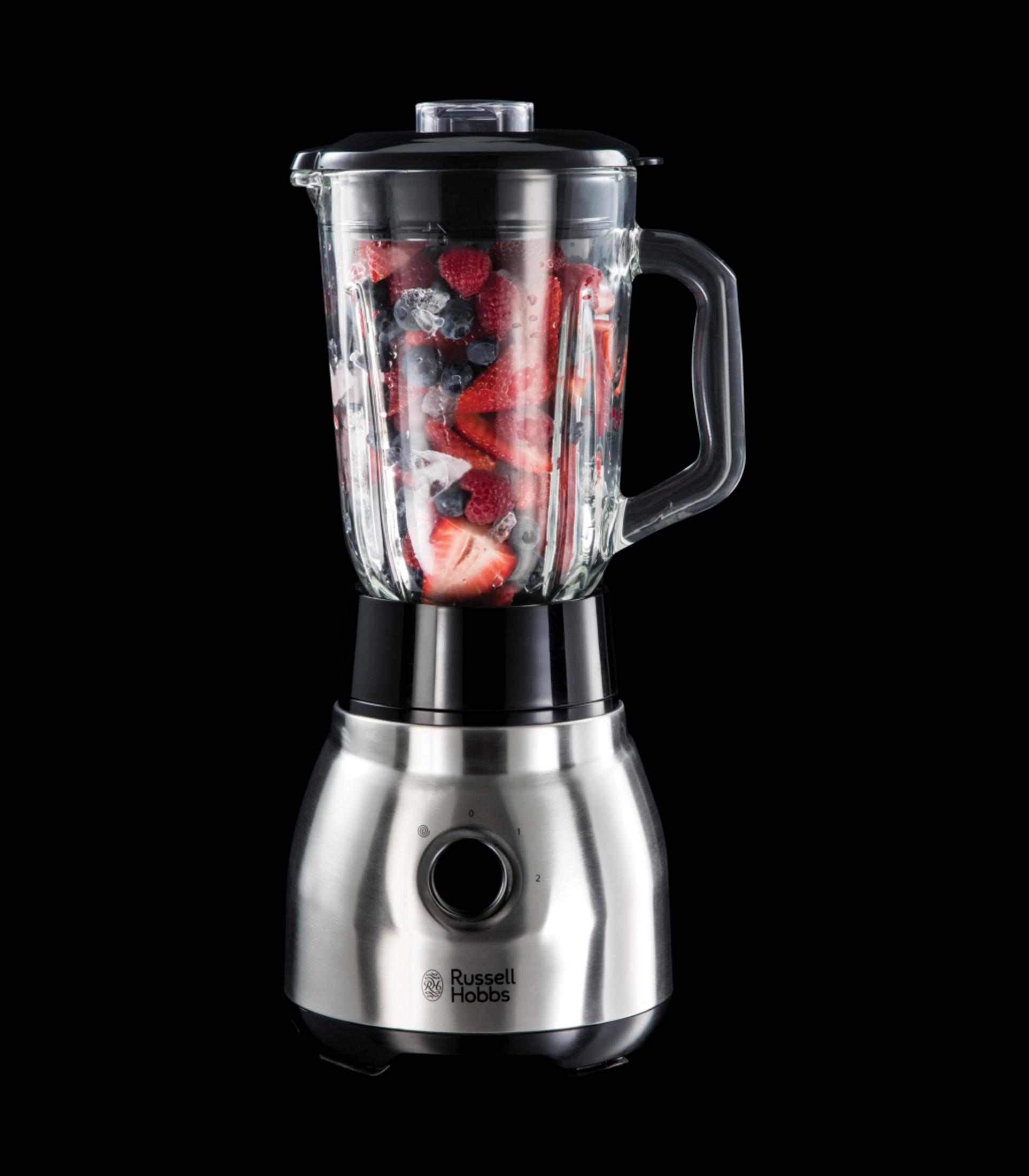 İçinde meyveler olan bir blender, siyah bir arka plan üzerinde. Paslanmaz çelik taban, saplı cam kavanoz, siyah kapak.