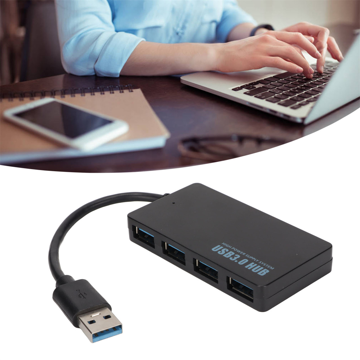 Ein schwarzer USB 3.0 Hub, verbunden mit einem Laptop. Auf dem Tisch liegen ein Telefon und ein Notizbuch.