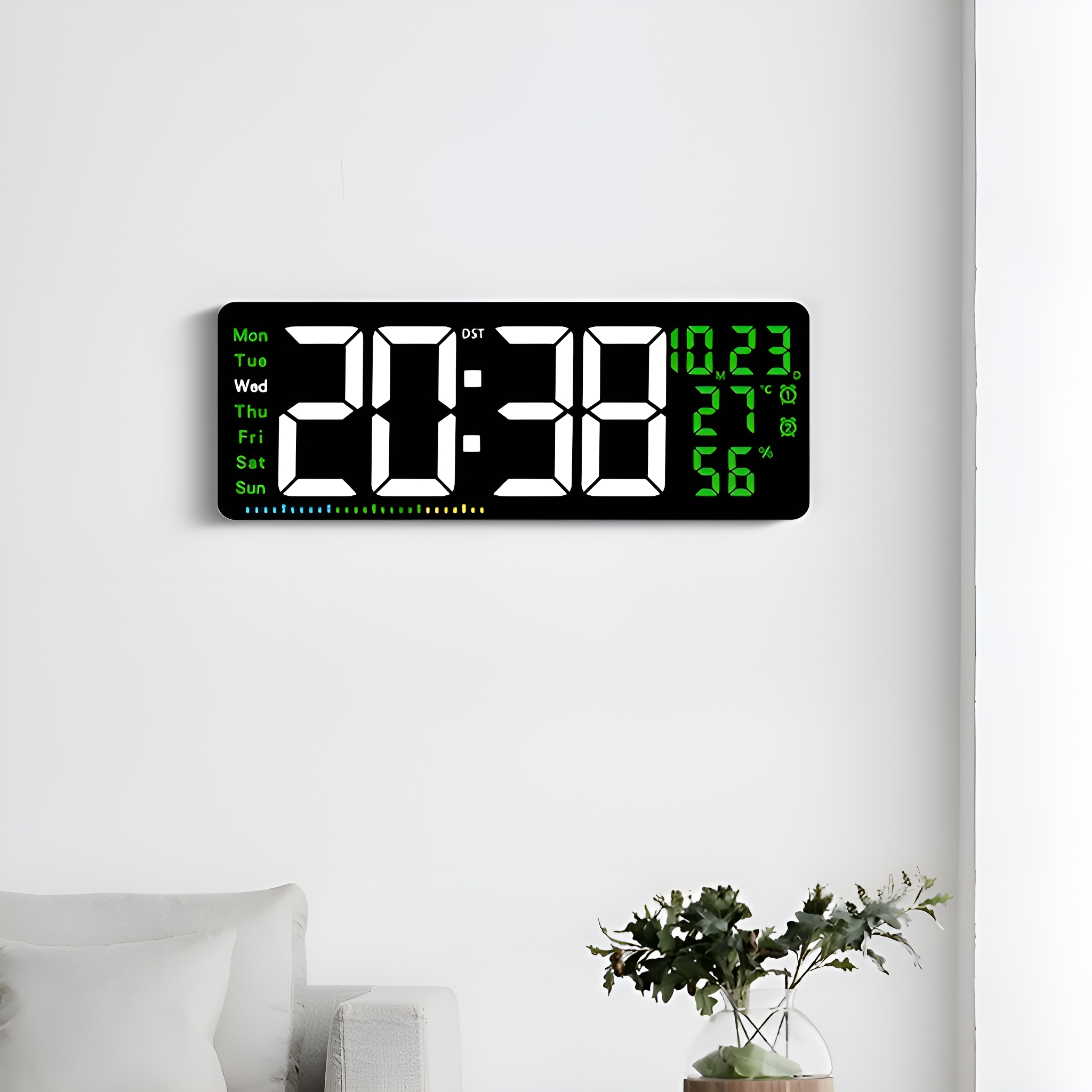 Digitaluhr an einer Wand. Zeigt Zeit, Datum, Temperatur und Luftfeuchtigkeit mit grüner Schrift an.