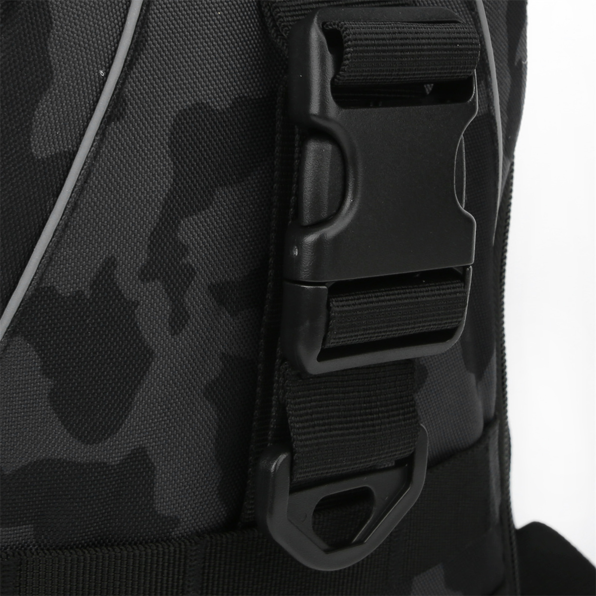 Nahaufnahme eines schwarzen Camouflage-Taschenriemens mit schwarzer Schnalle.
