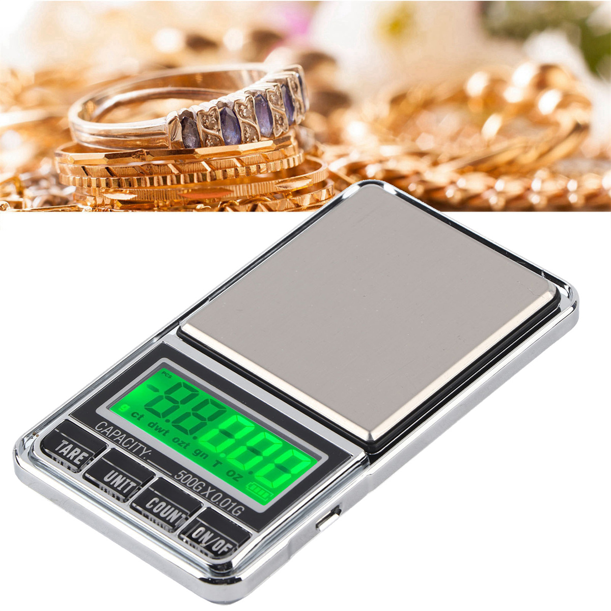 Kleine Digitalwaage mit grüner Anzeige, die ein Gewicht anzeigt. Schmuck und Münzen sind im Hintergrund.