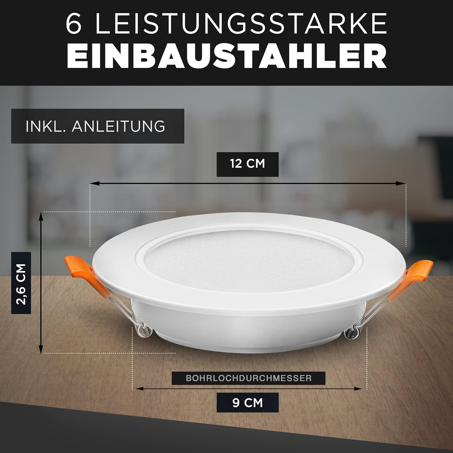 Weißes Einbau-Deckenlicht mit orangen Clips und Abmessungen. Holzuntergrund.